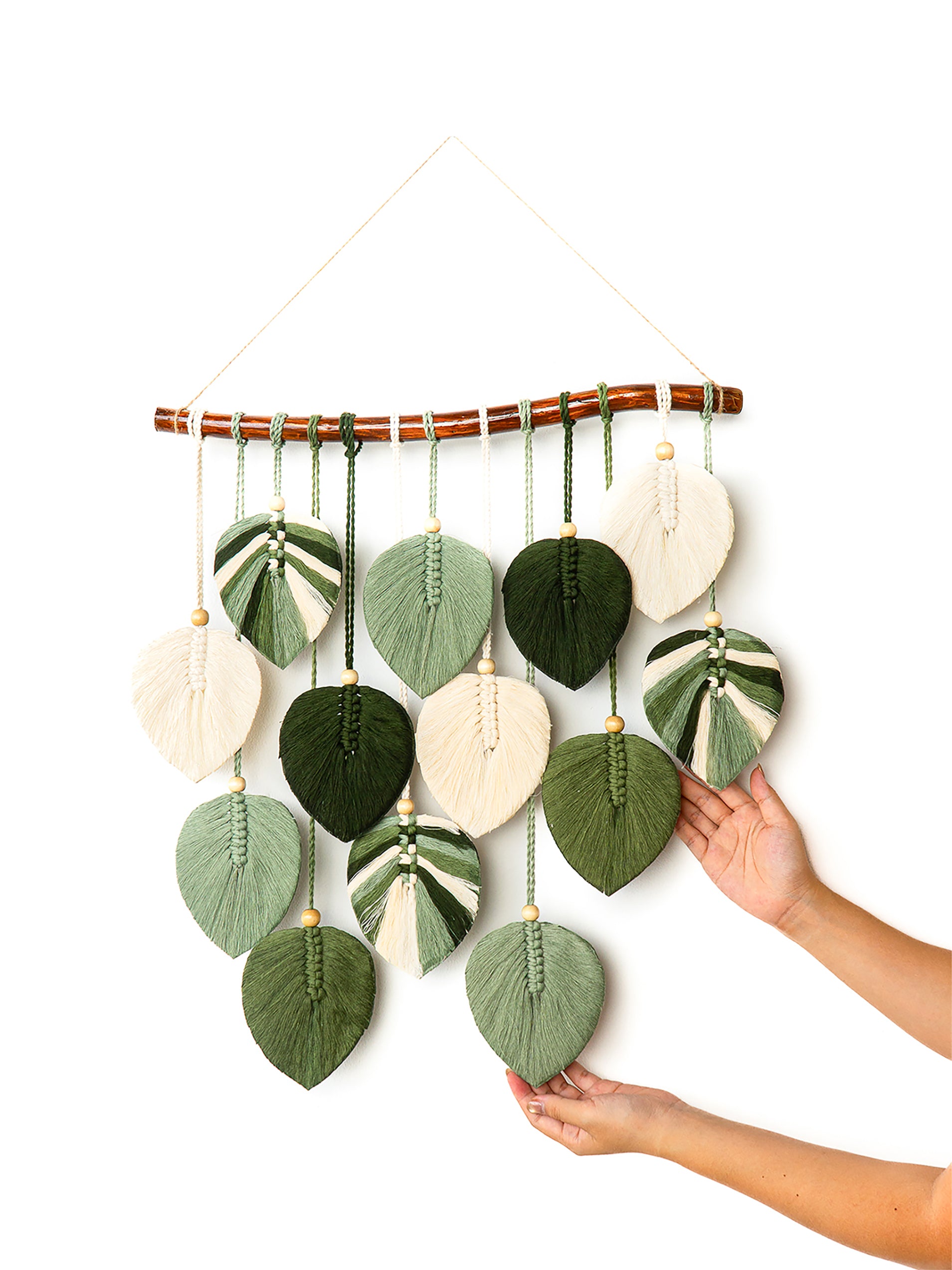 Colorful leaf-shaped wall hanging with beads on a white background