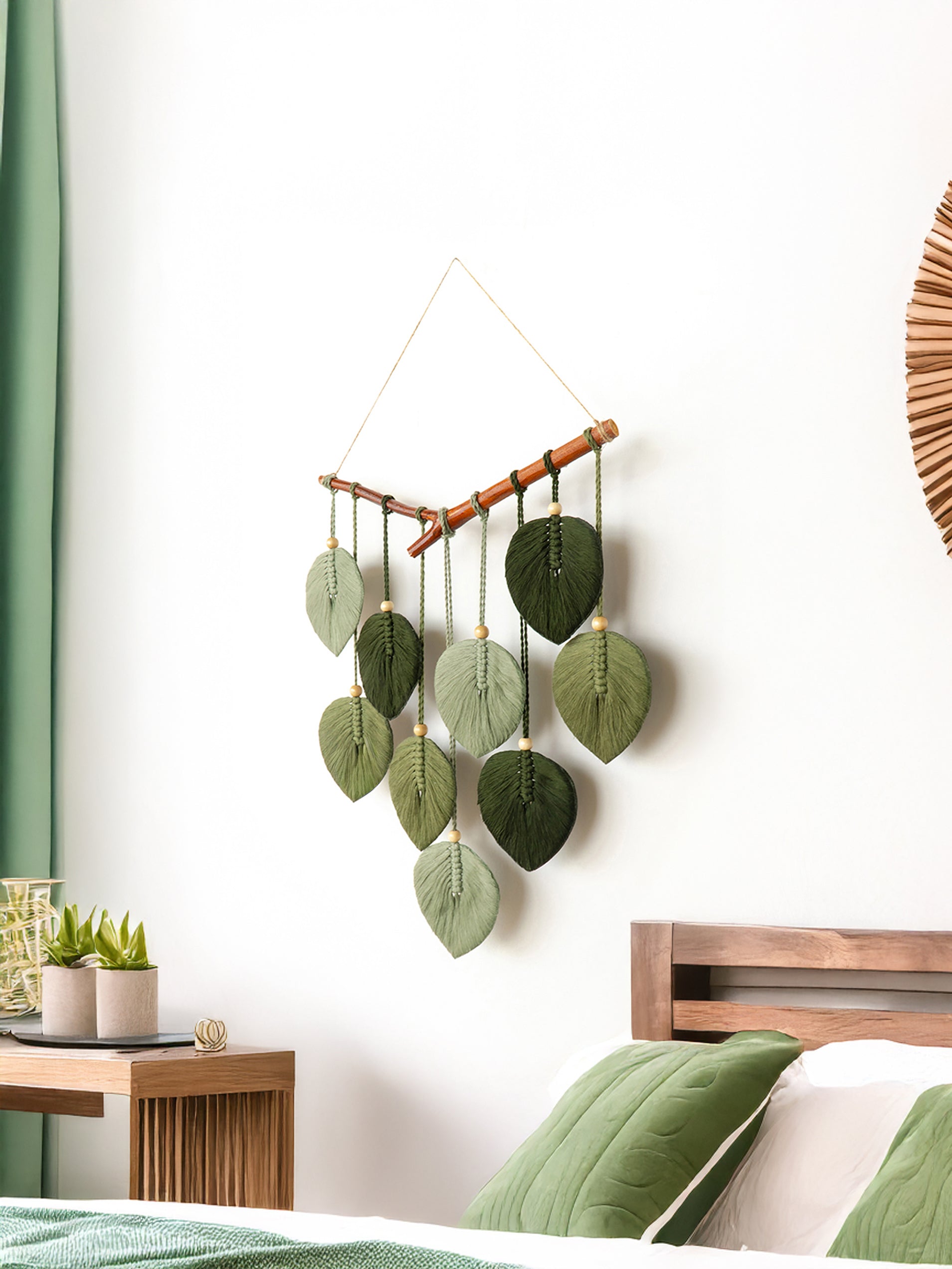 Decorative wall hanging with green leaves in a bedroom setting