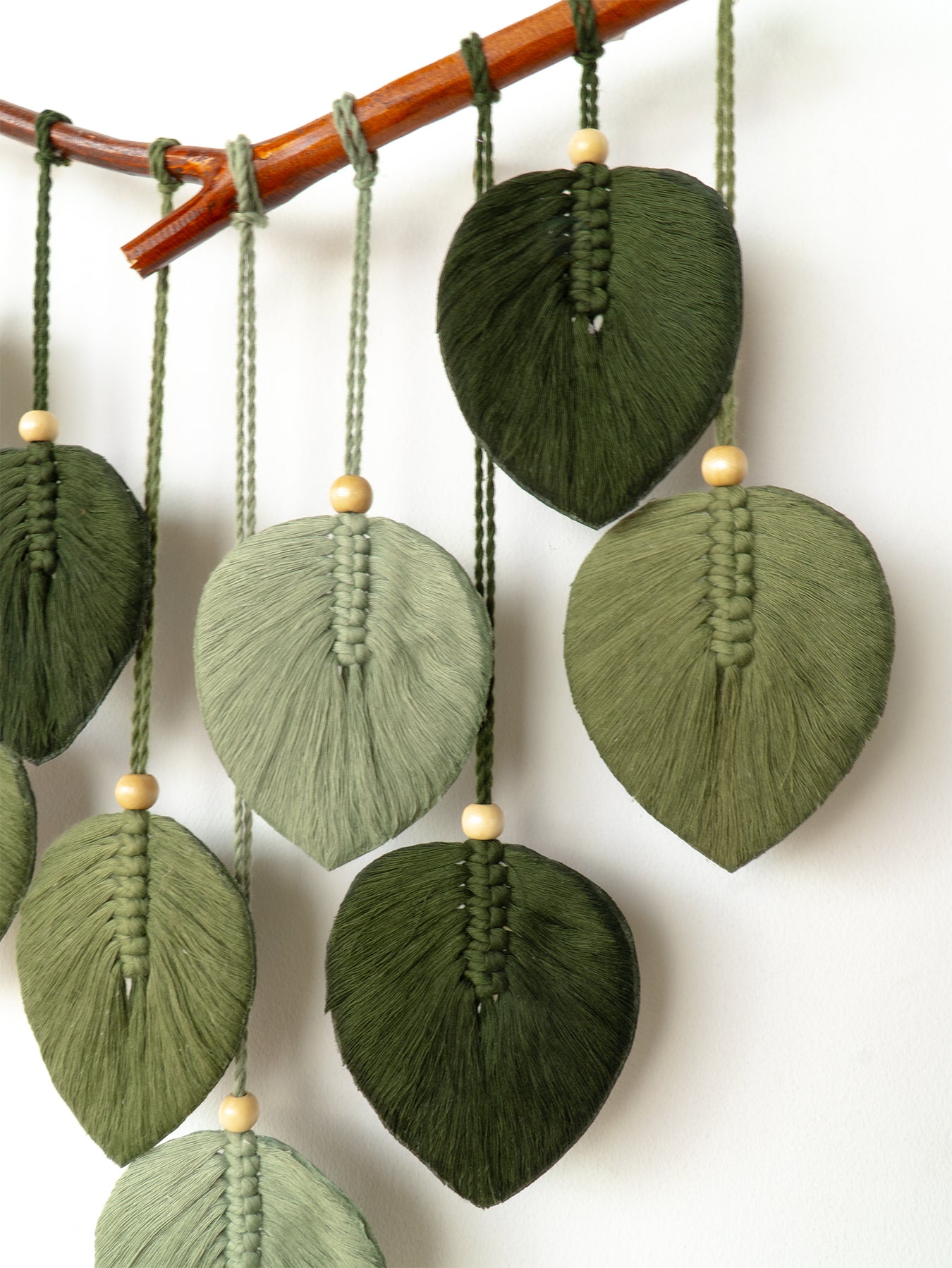 Decorative wall hanging with colorful leaf-shaped beads on a white background