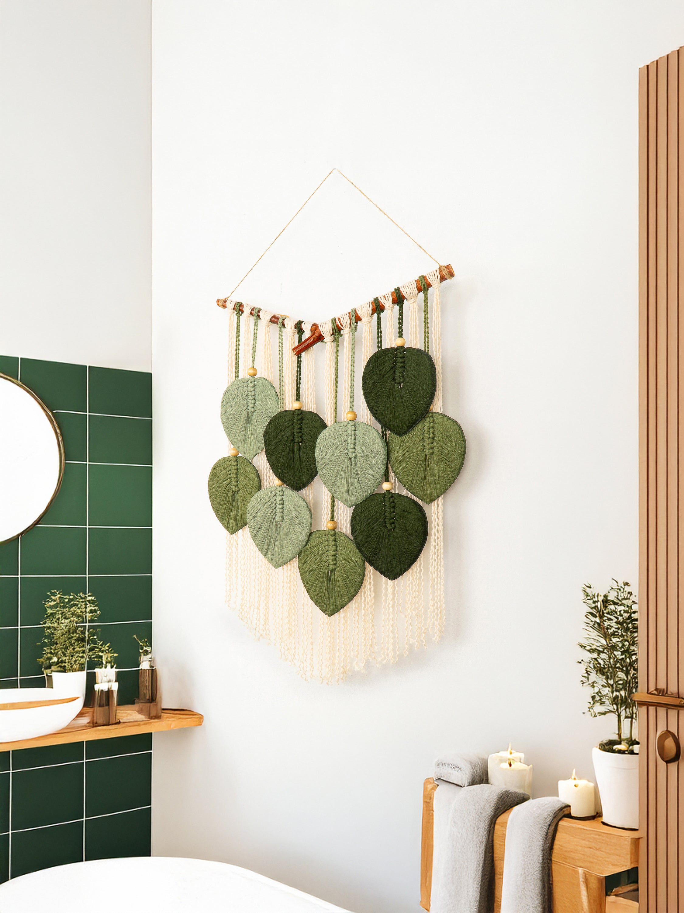 Decorative wall hanging with green leaf-shaped elements in a bathroom setting.
