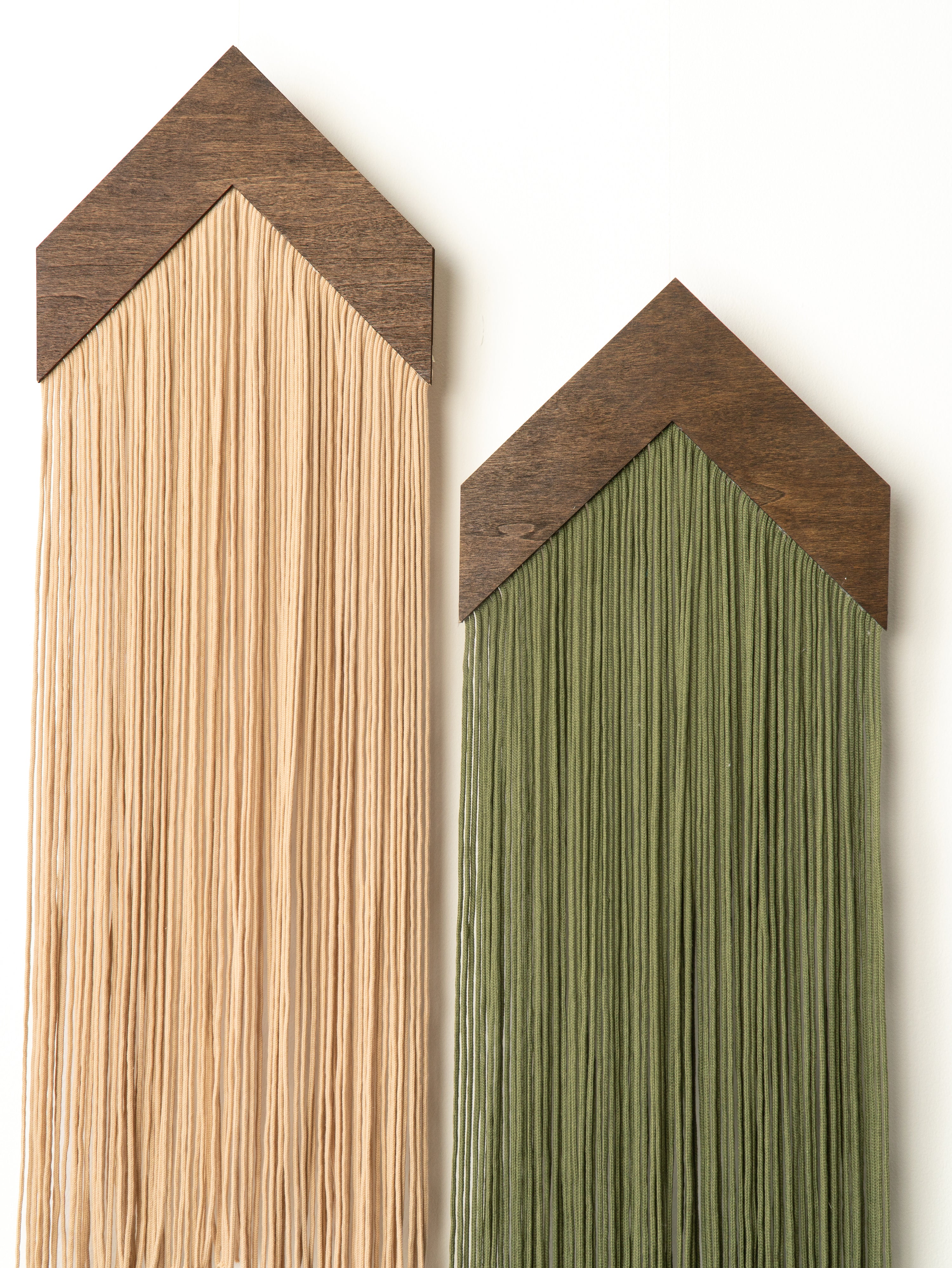 Two wooden wall art pieces with a natural wood finish and green finish on a white background.