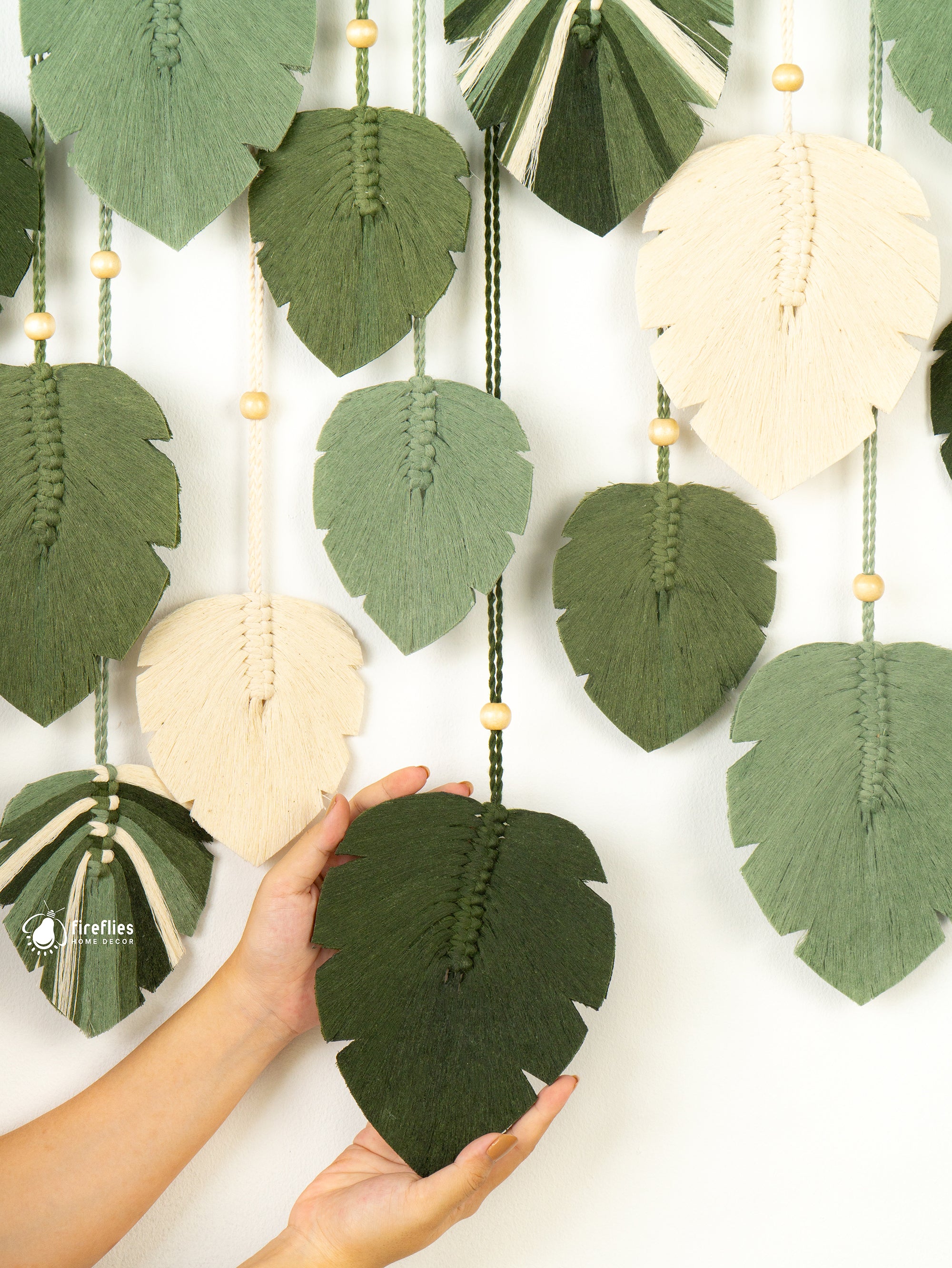 Decorative wall hanging with leaf-shaped fabric pieces on a white background