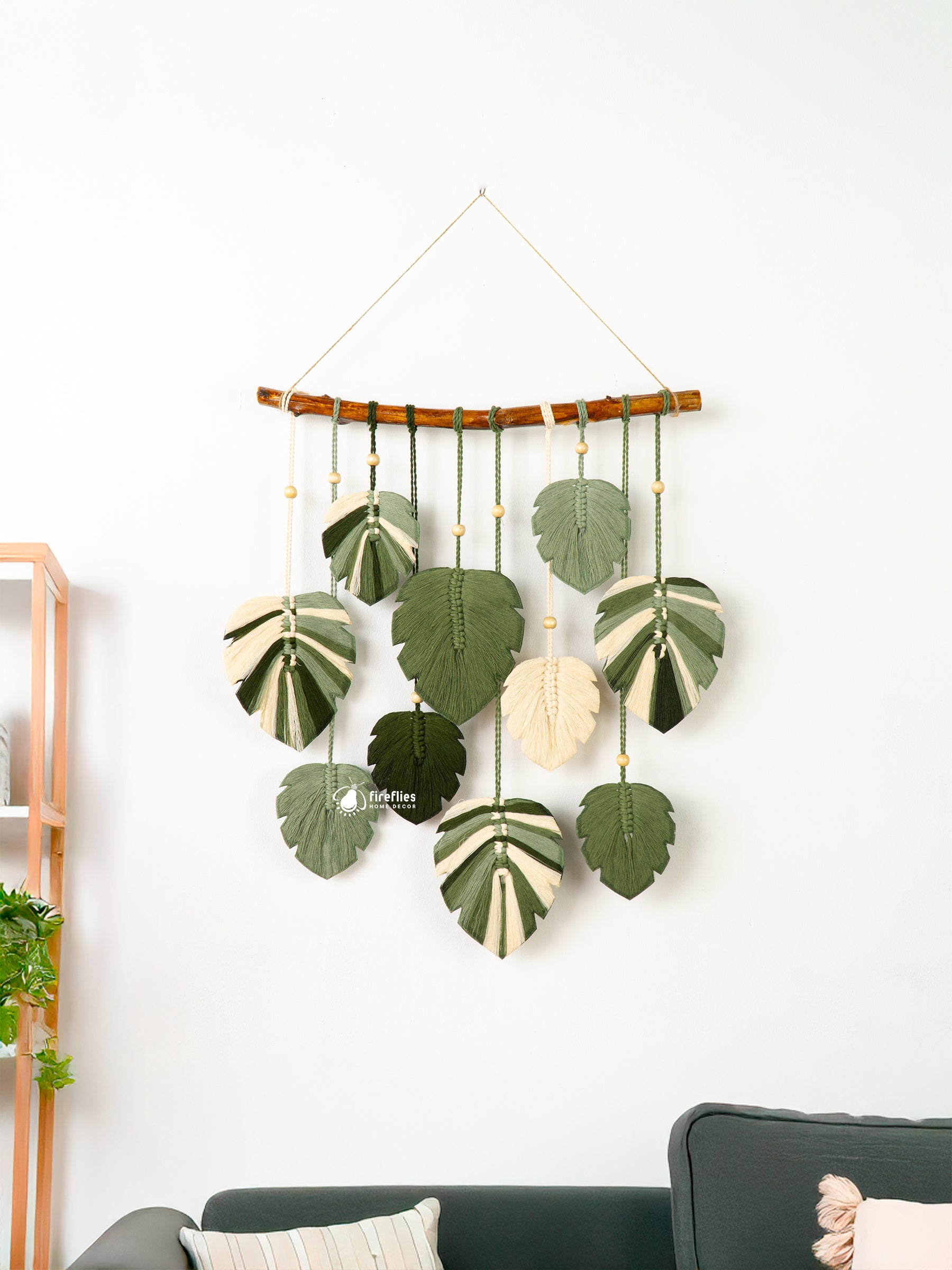 Decorative wall hanging with leaf patterns on a white wall.