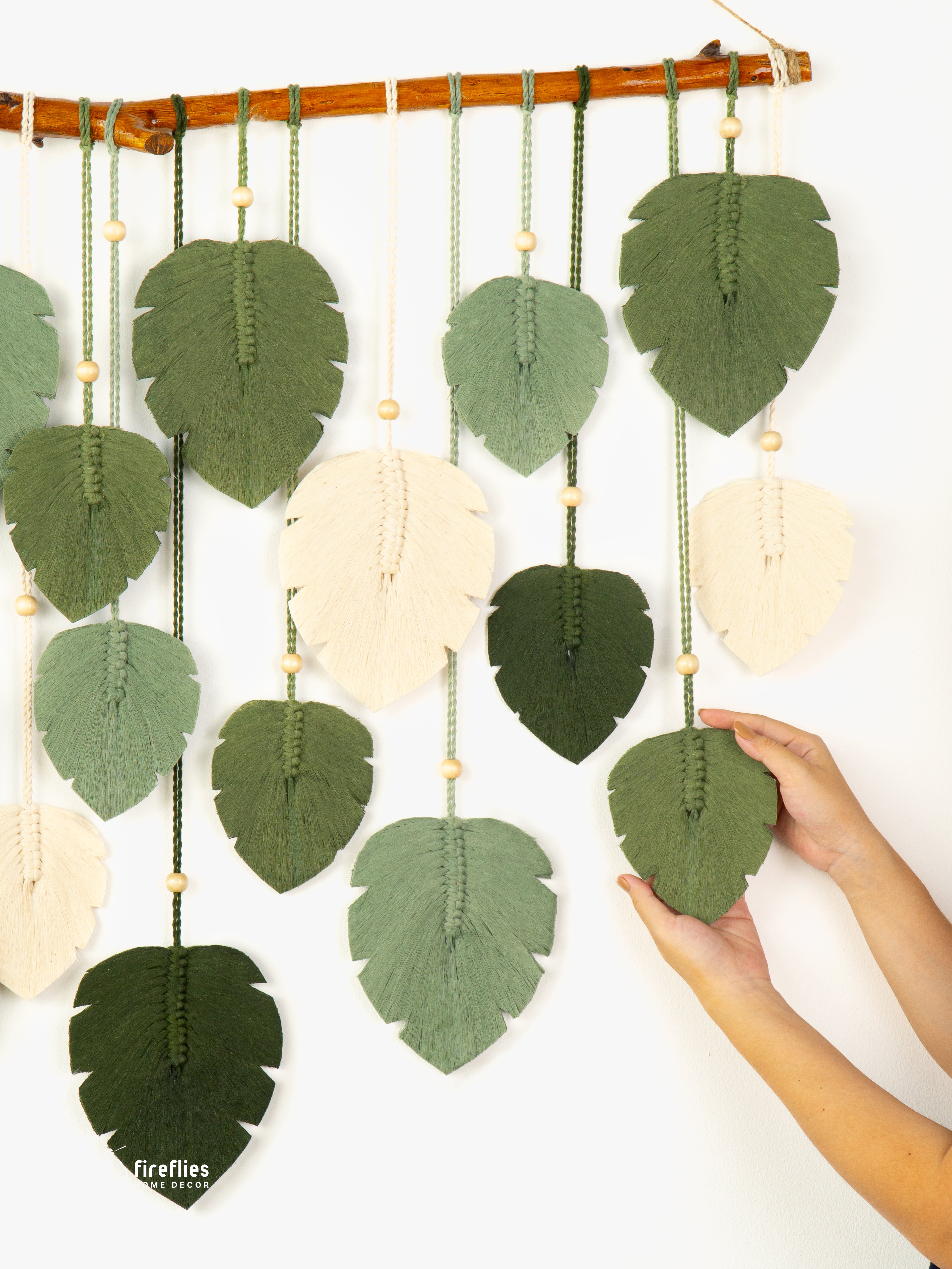 Decorative wall hanging with leaf-shaped fabric pieces on a white background