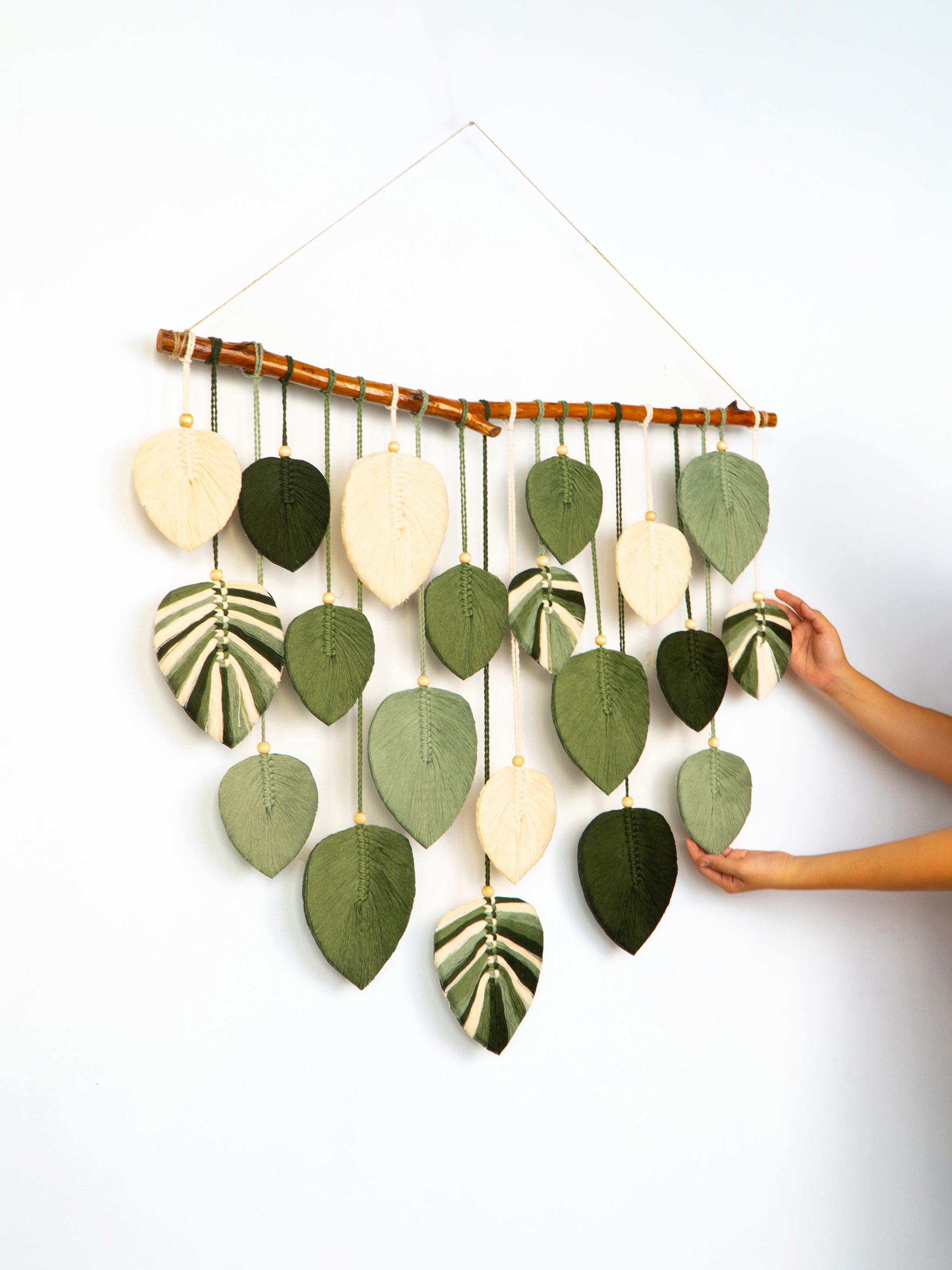 Wall hanging with leaf-shaped decorations on a white background
