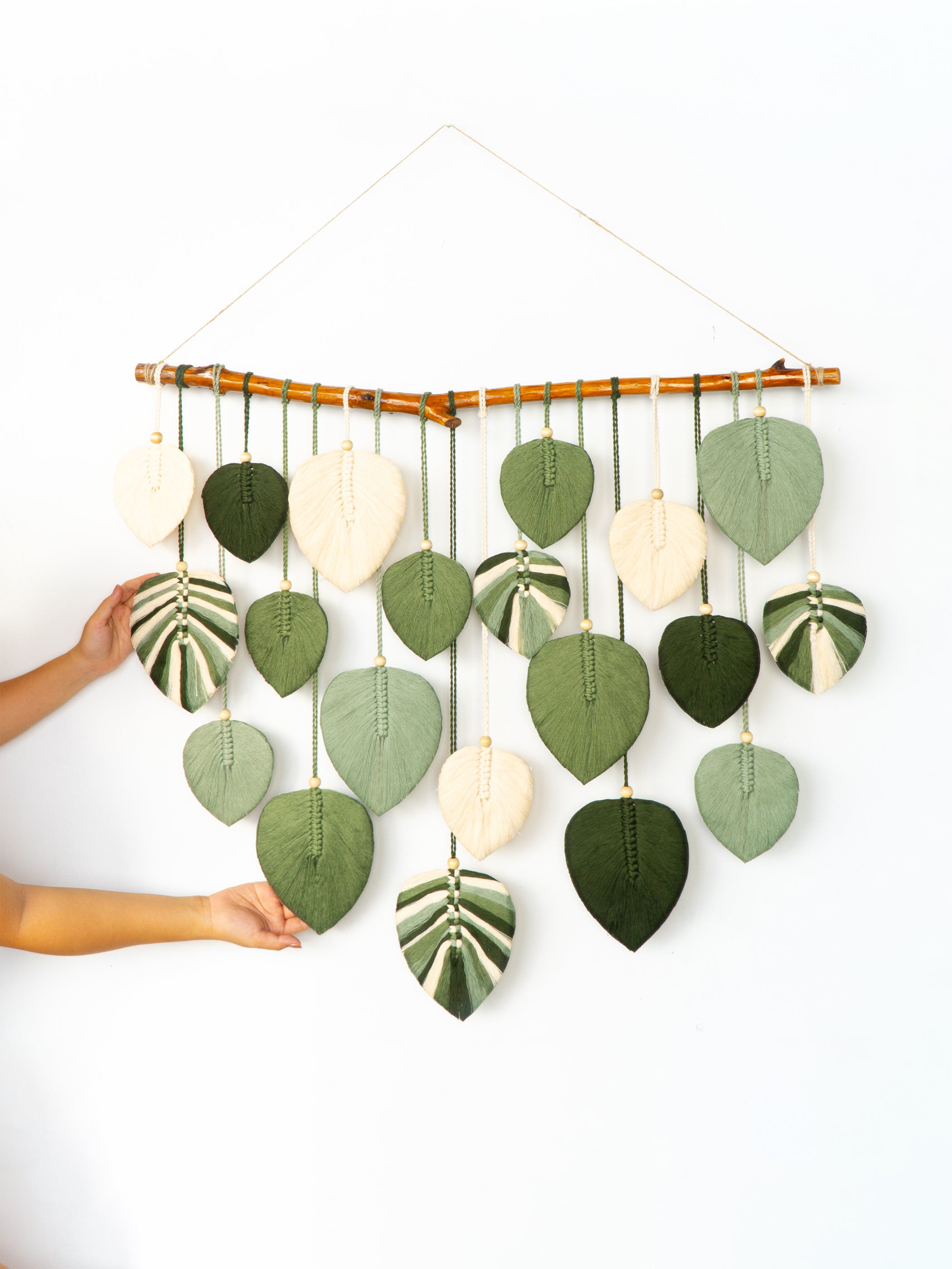 Decorative wall hanging with leaf-shaped elements on a white background