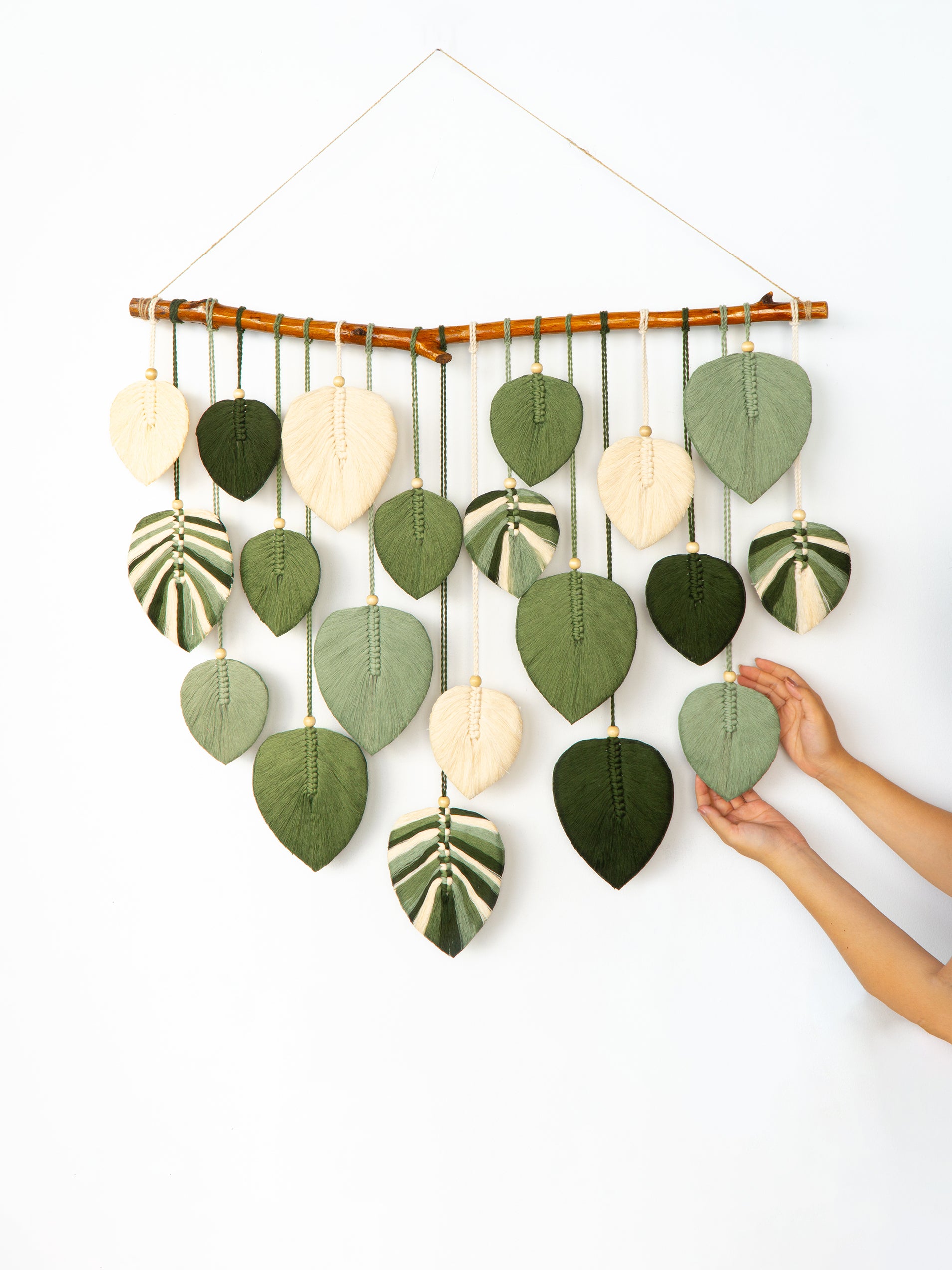 Wall hanging with leaf-shaped decorations on a white background