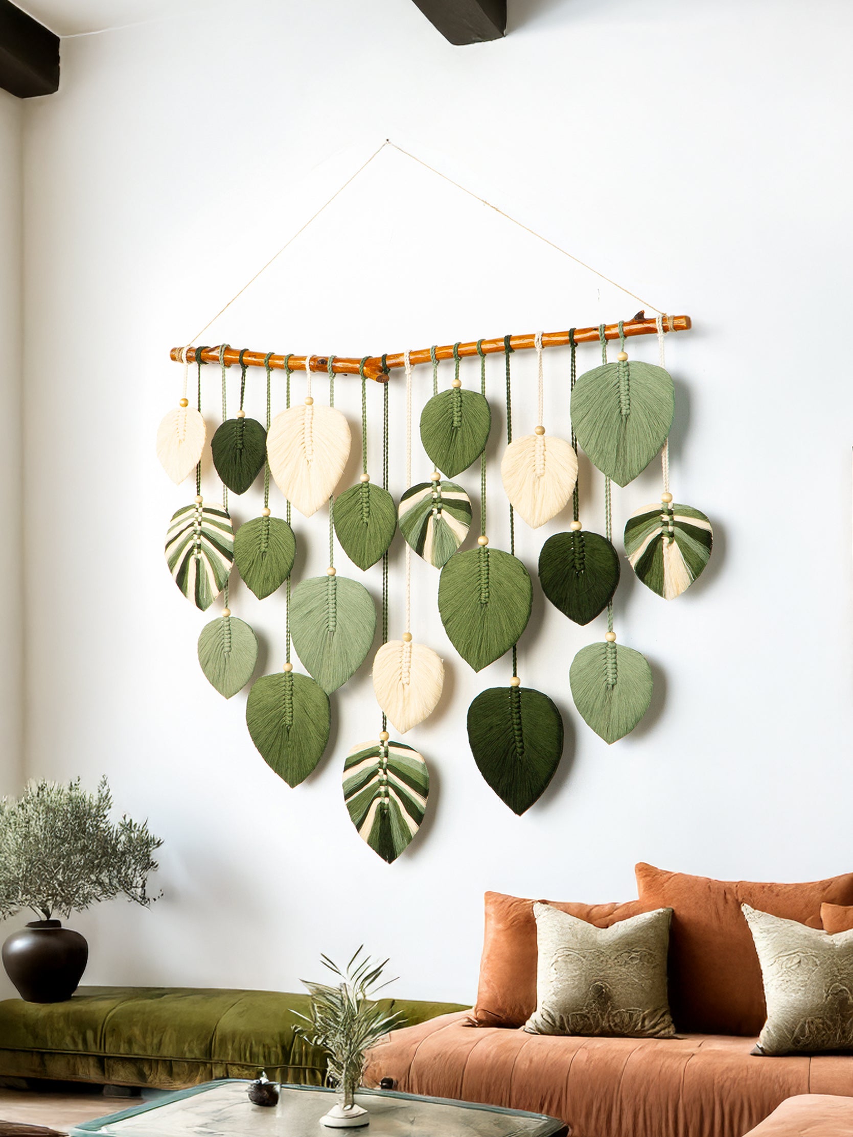 Decorative wall hanging with leaf-shaped felt pieces in a living room setting.