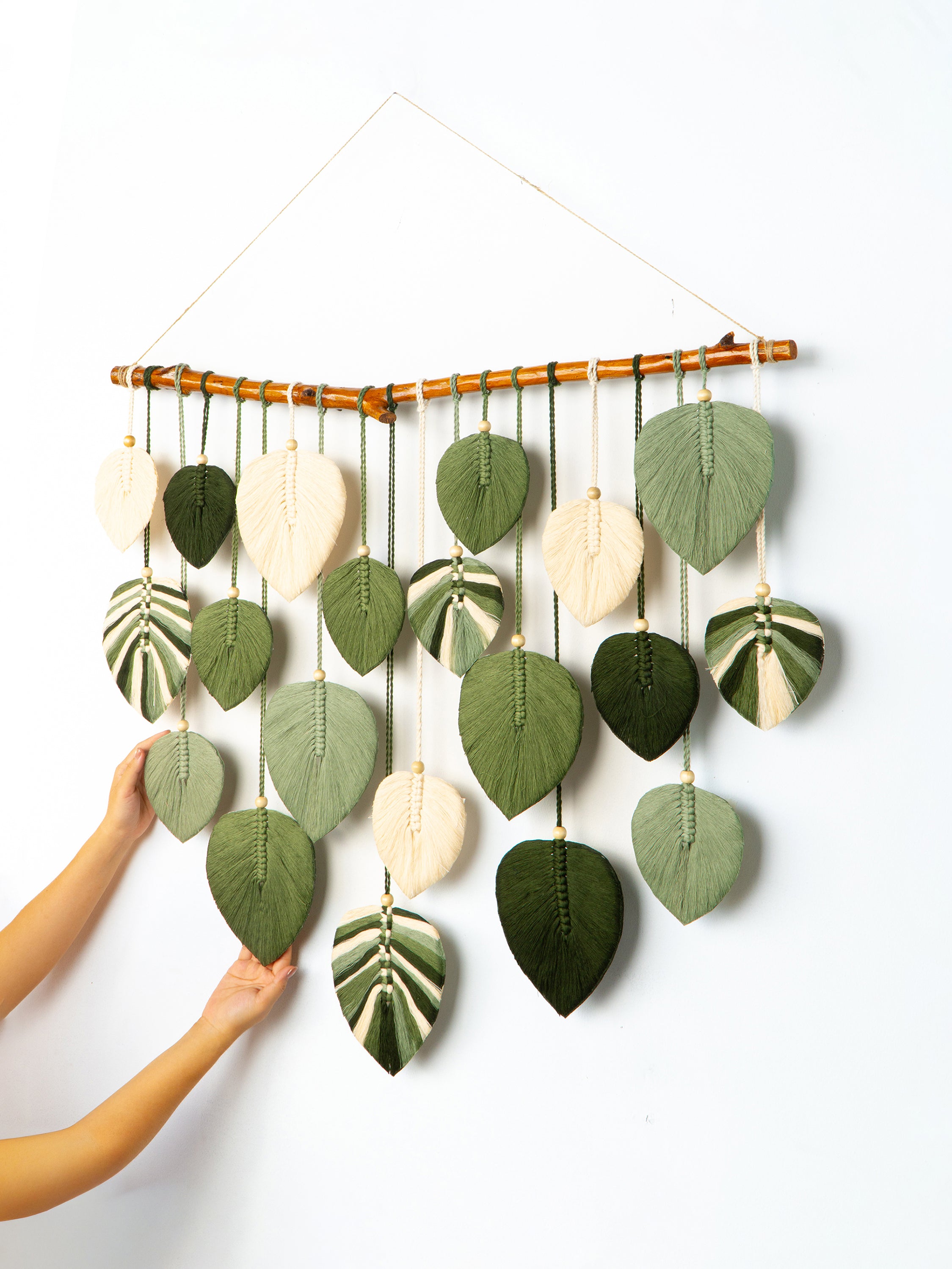 Decorative wall hanging with leaf-shaped ornaments on a white background