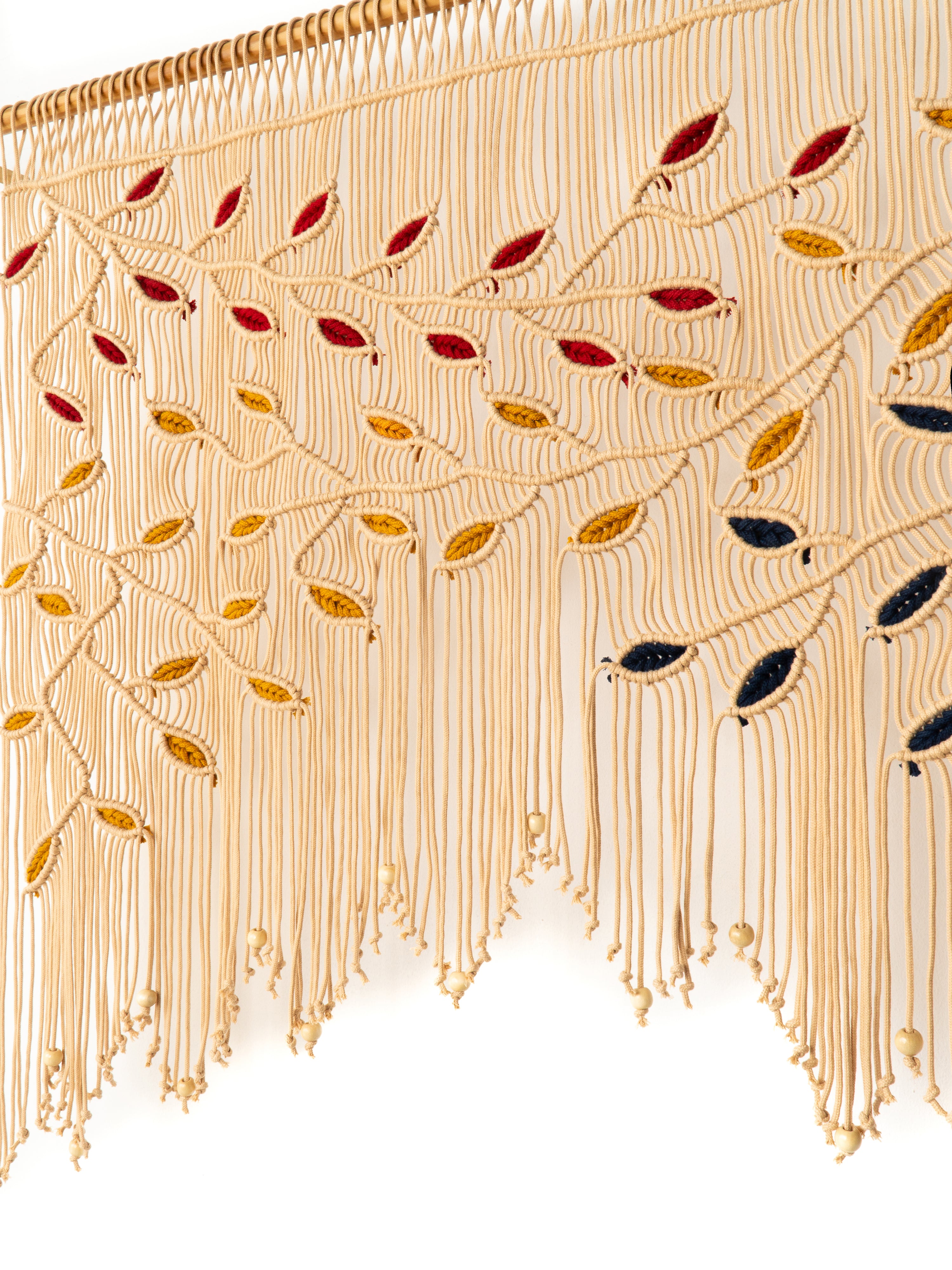Decorative fabric with gold fringe and colored leaves on a white background