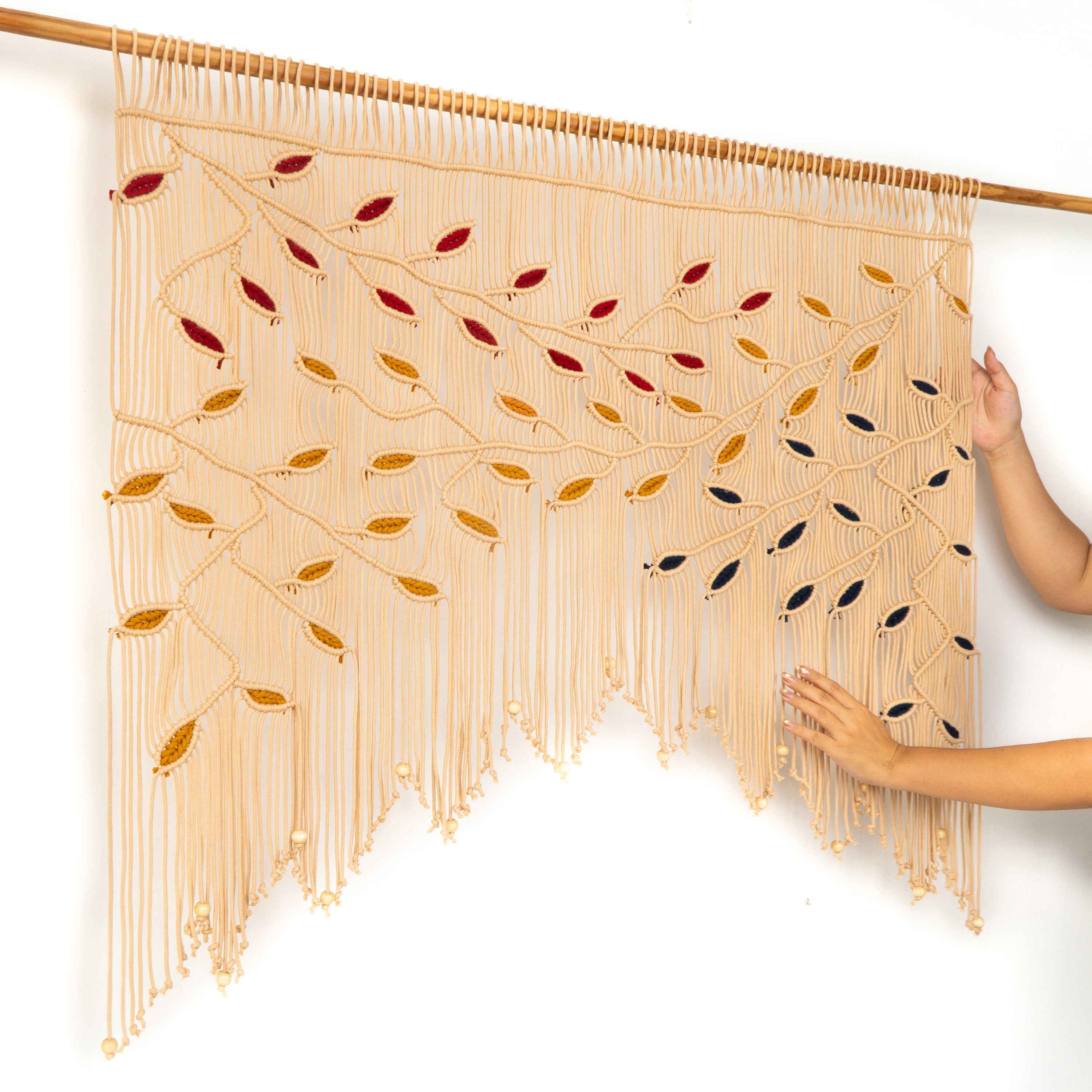 Macrame wall hanging with colorful beads on a white background