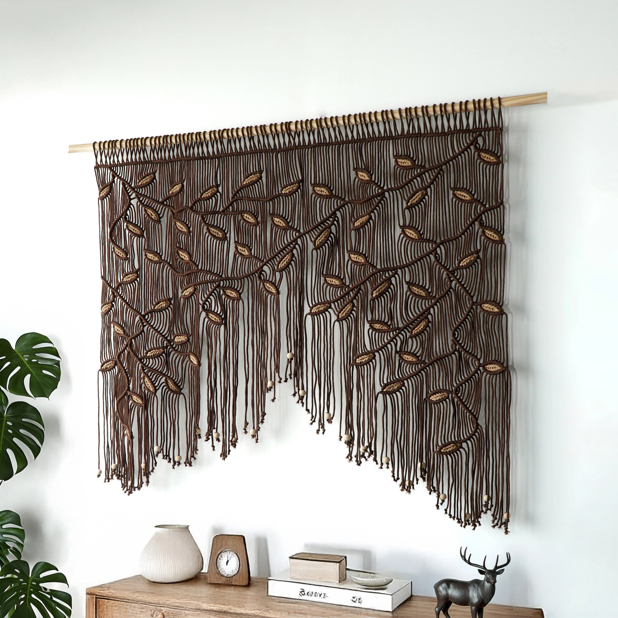 Intricate cocoa fiber art headboard with cascading tan leaf vines and a beaded scalloped edge.