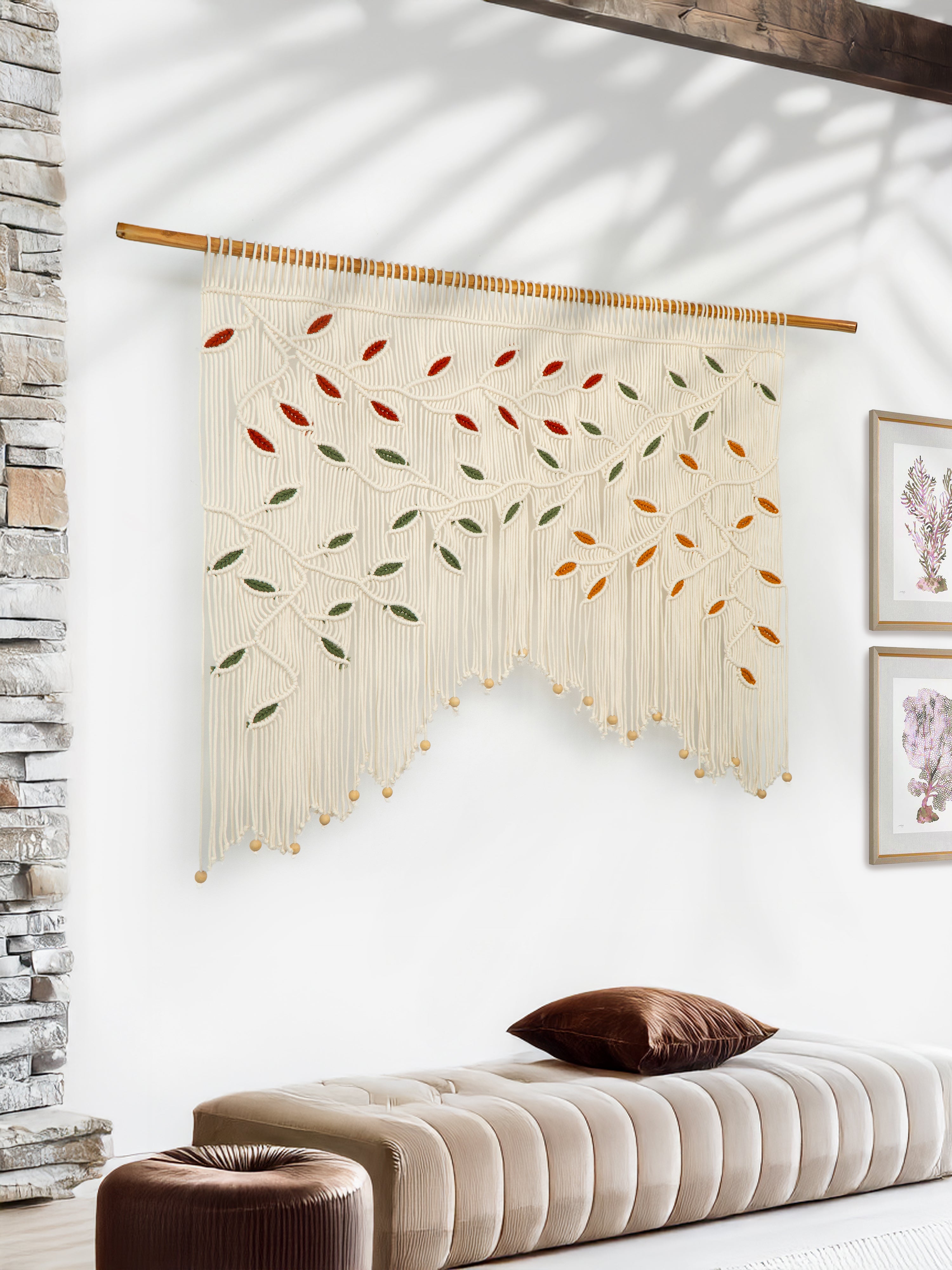 Decorative wall hanging with leaf pattern in a room with a bench and framed pictures.