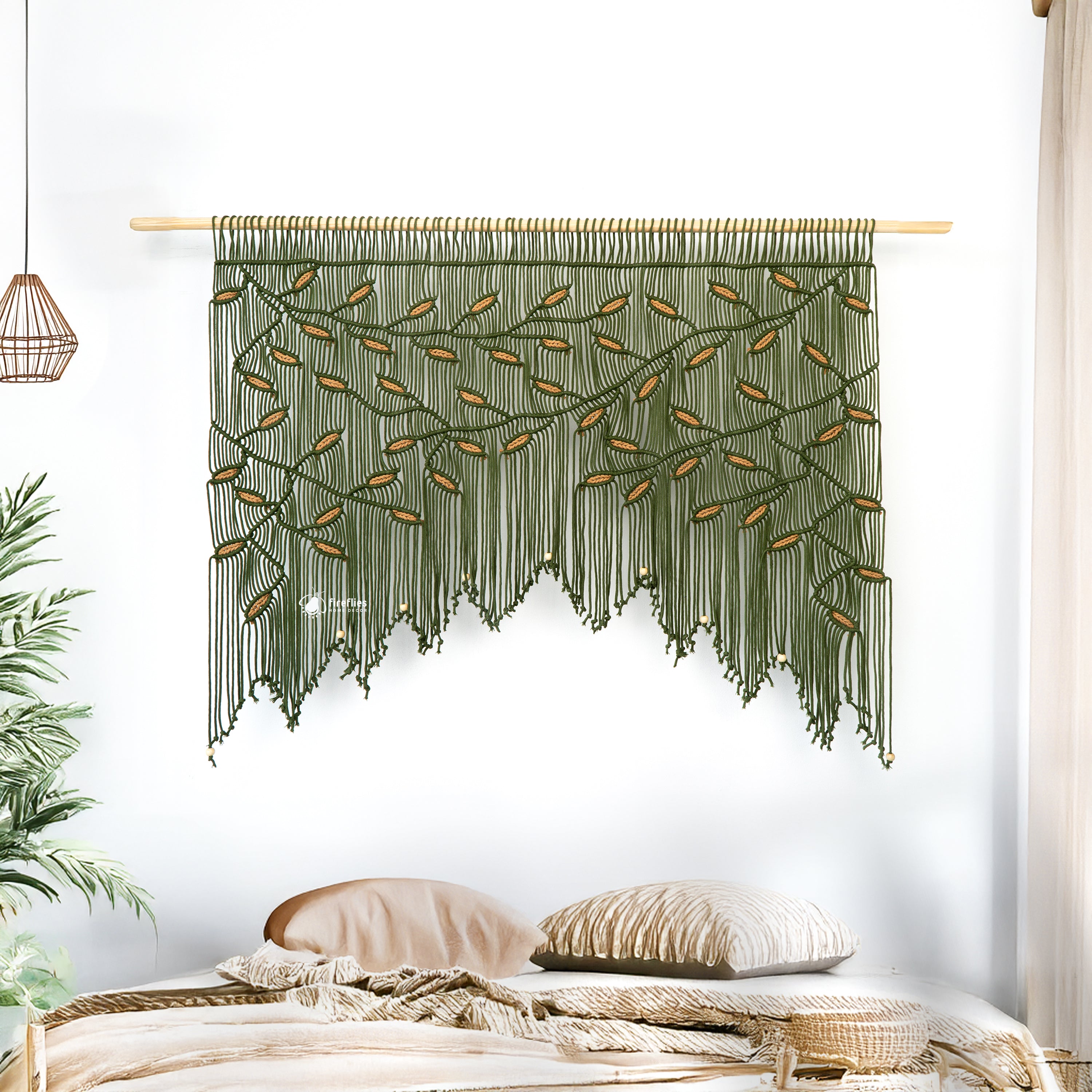 Green woven wall hanging with leaf patterns on a white wall.