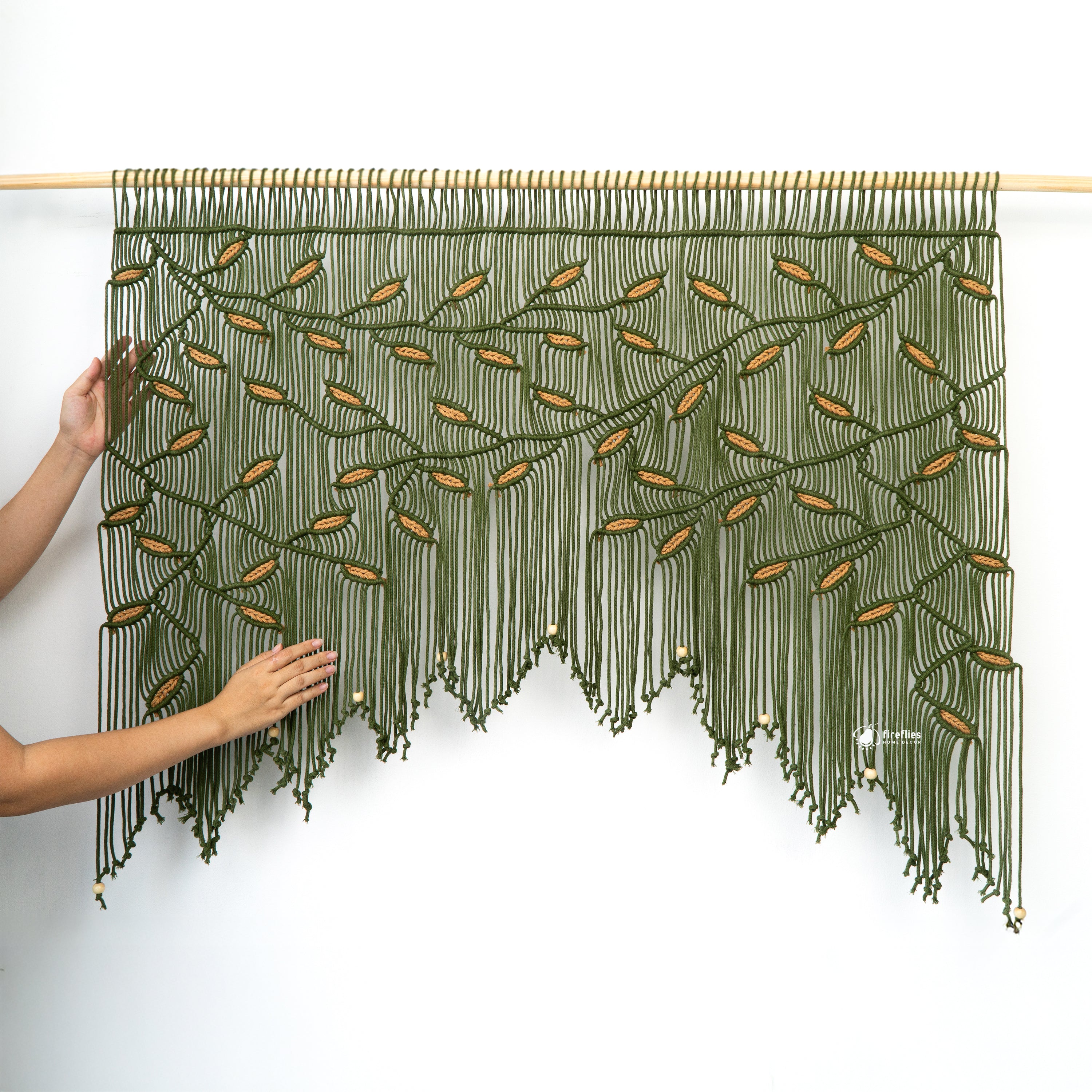 Textured green fabric with leaf pattern and fringe, featuring a brand logo.
