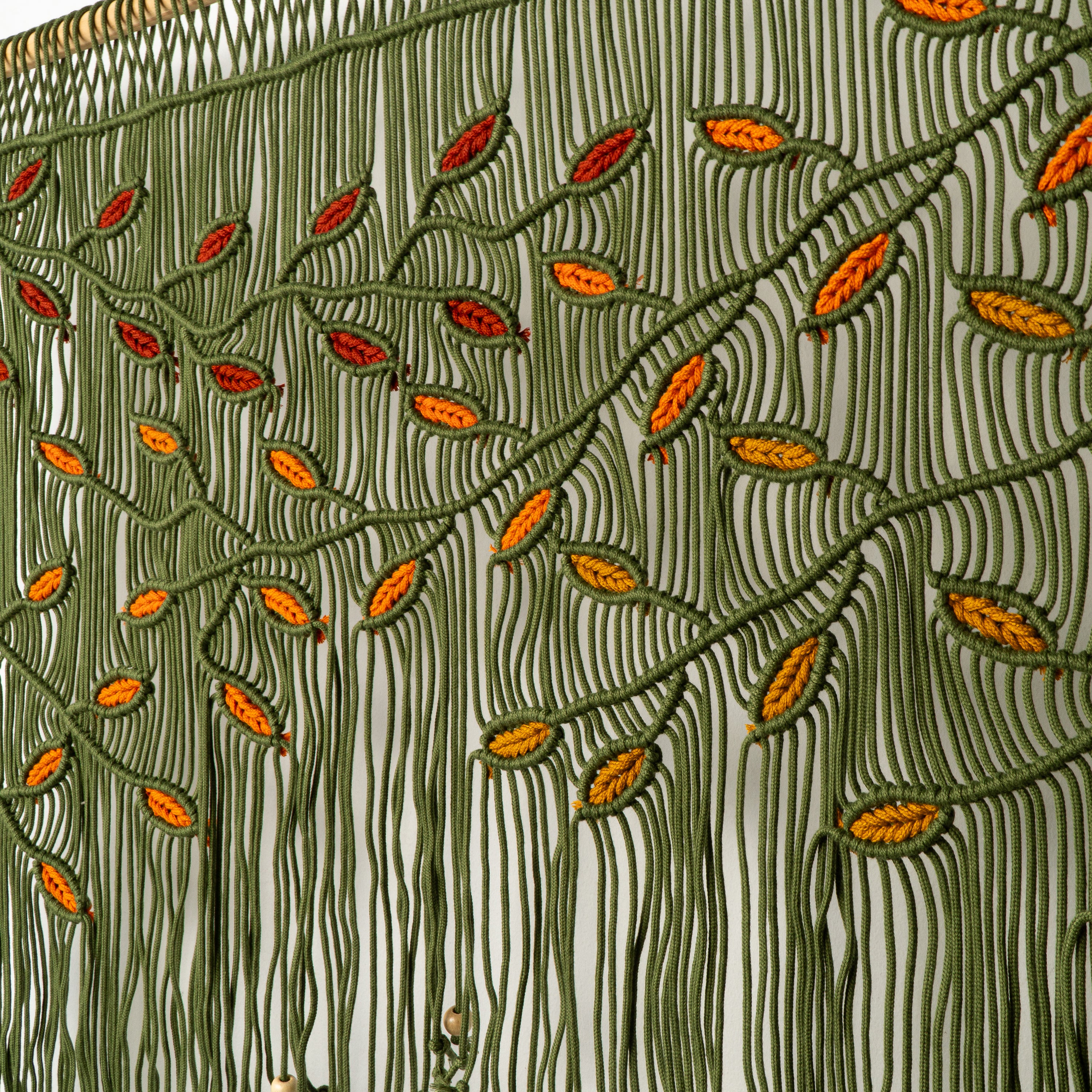 Close-up of embroidered fabric with leaf pattern on a white background