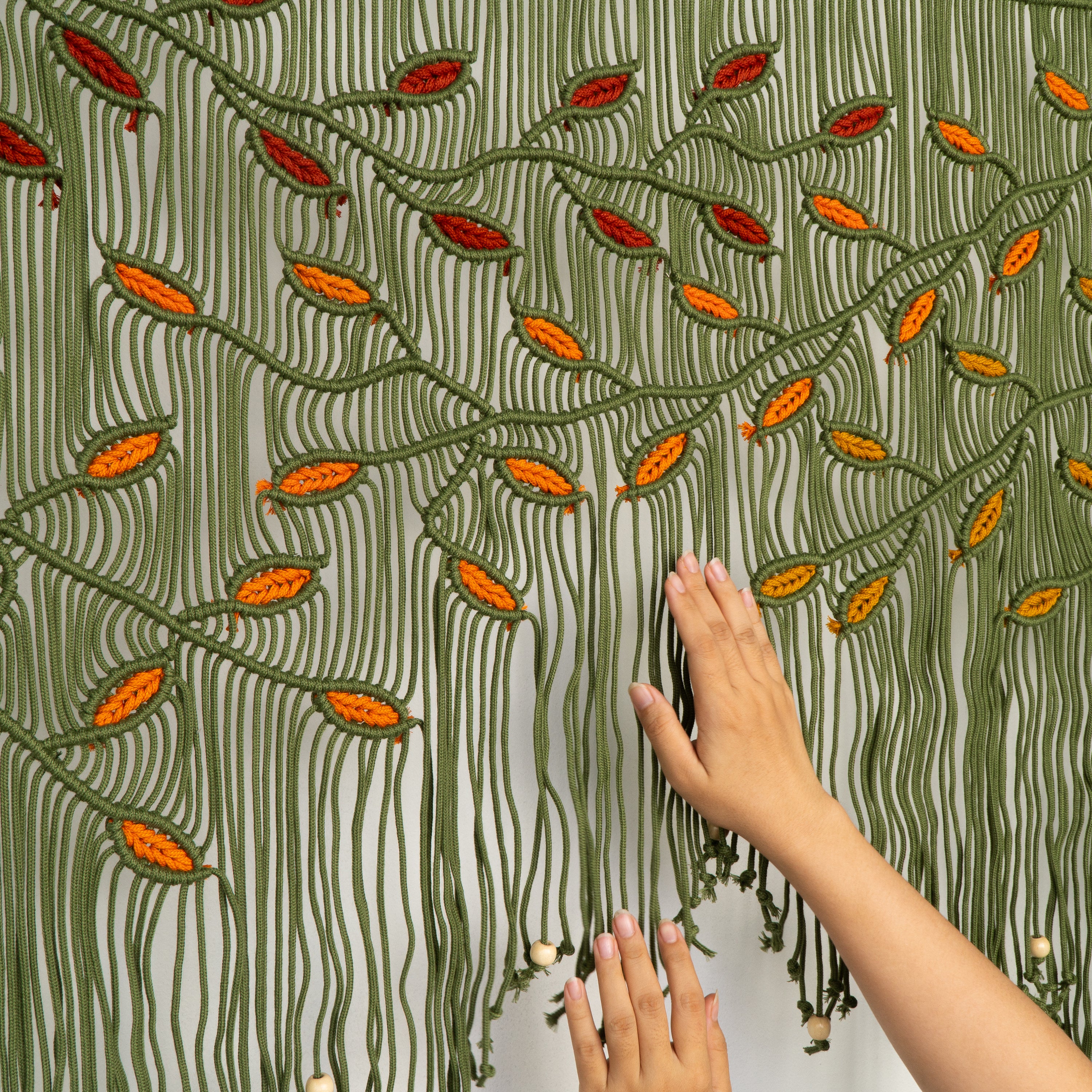 Hand touching a textured fabric with leaf pattern