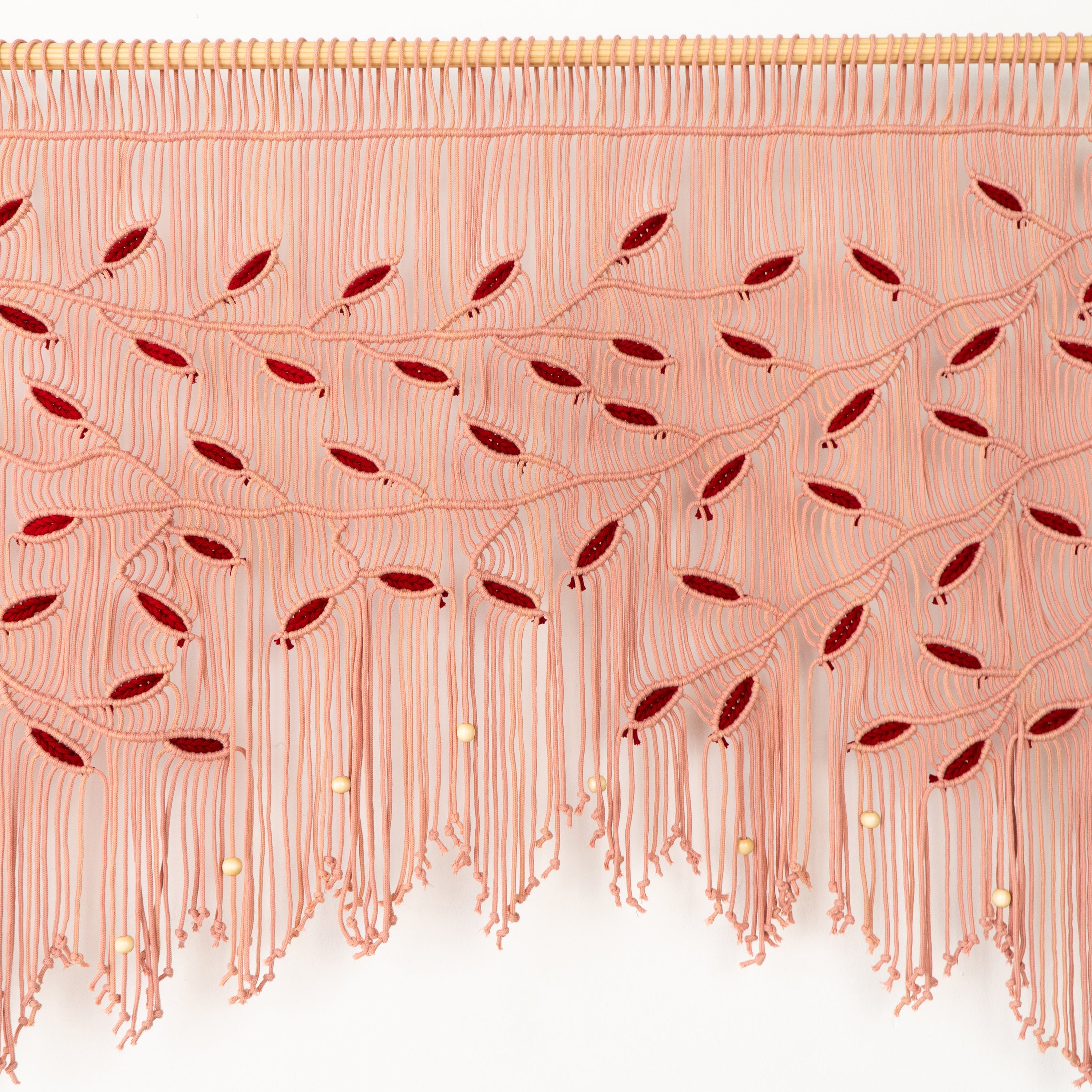 Decorative pink fringe curtain with red accents on a white background