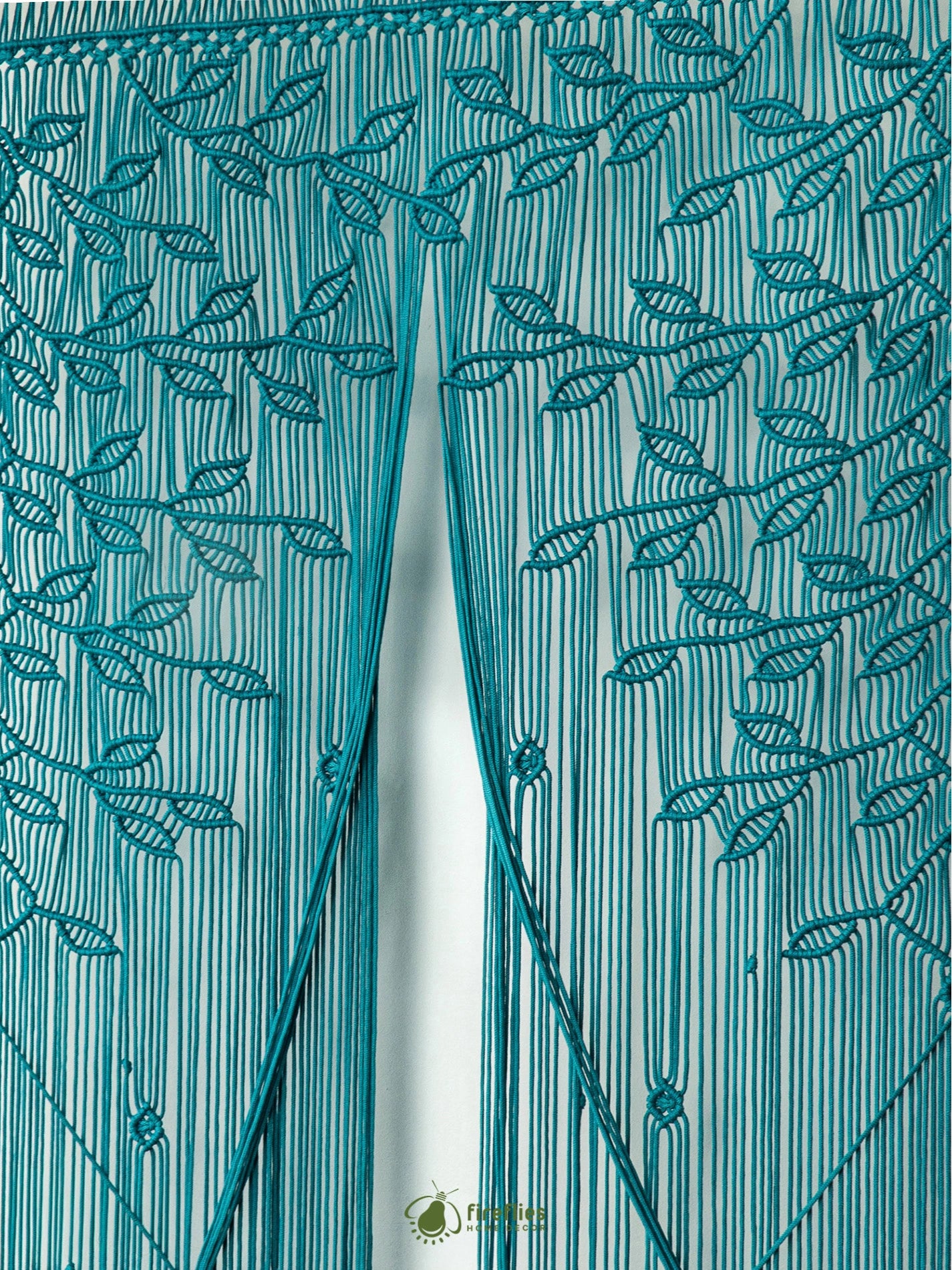 Detailed botanical leaf canopy knotwork on a rich aqua blue cotton macrame curtain panel.