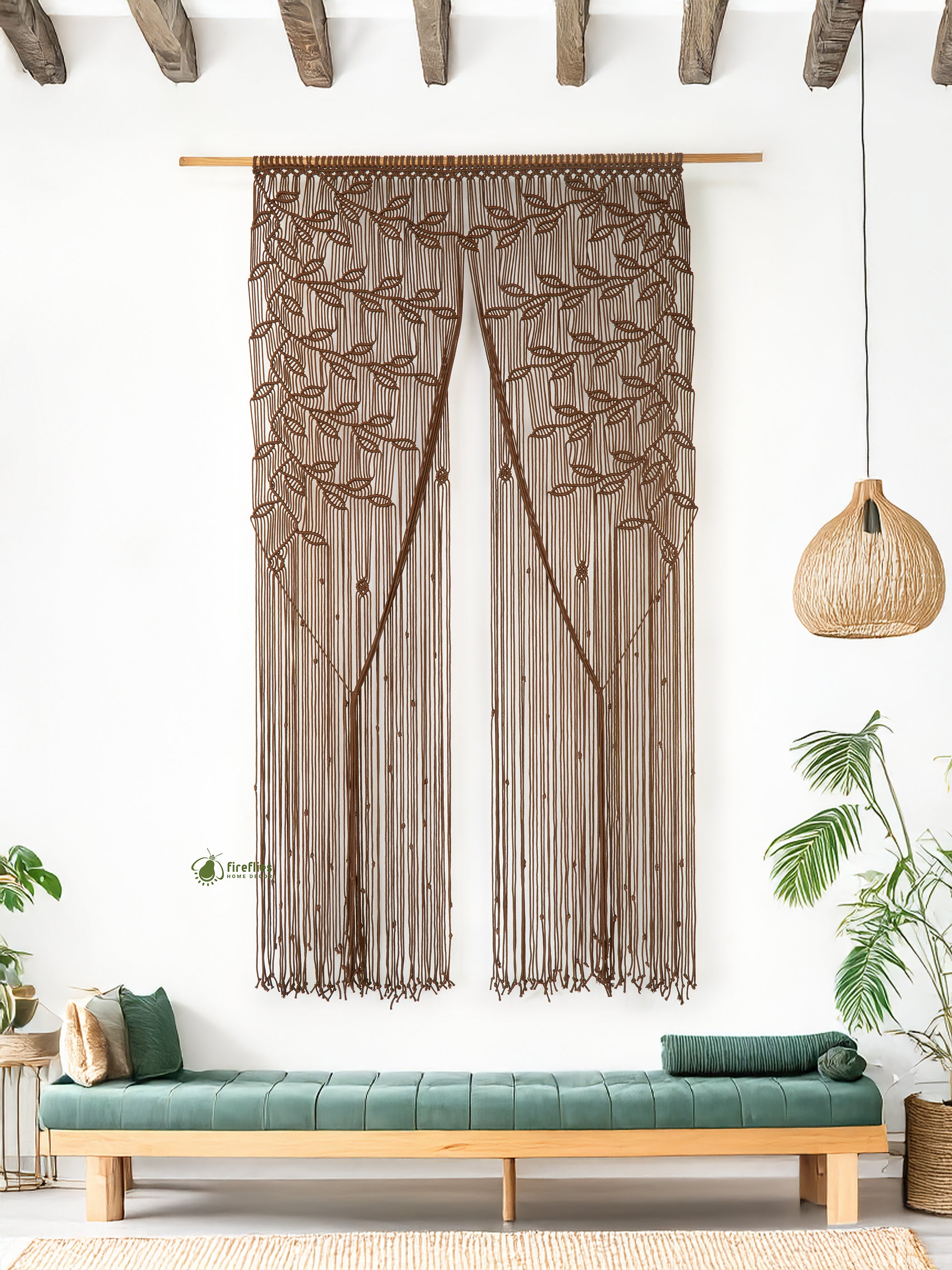 Decorative curtain with leaf pattern hanging above a bench in a room with plants.