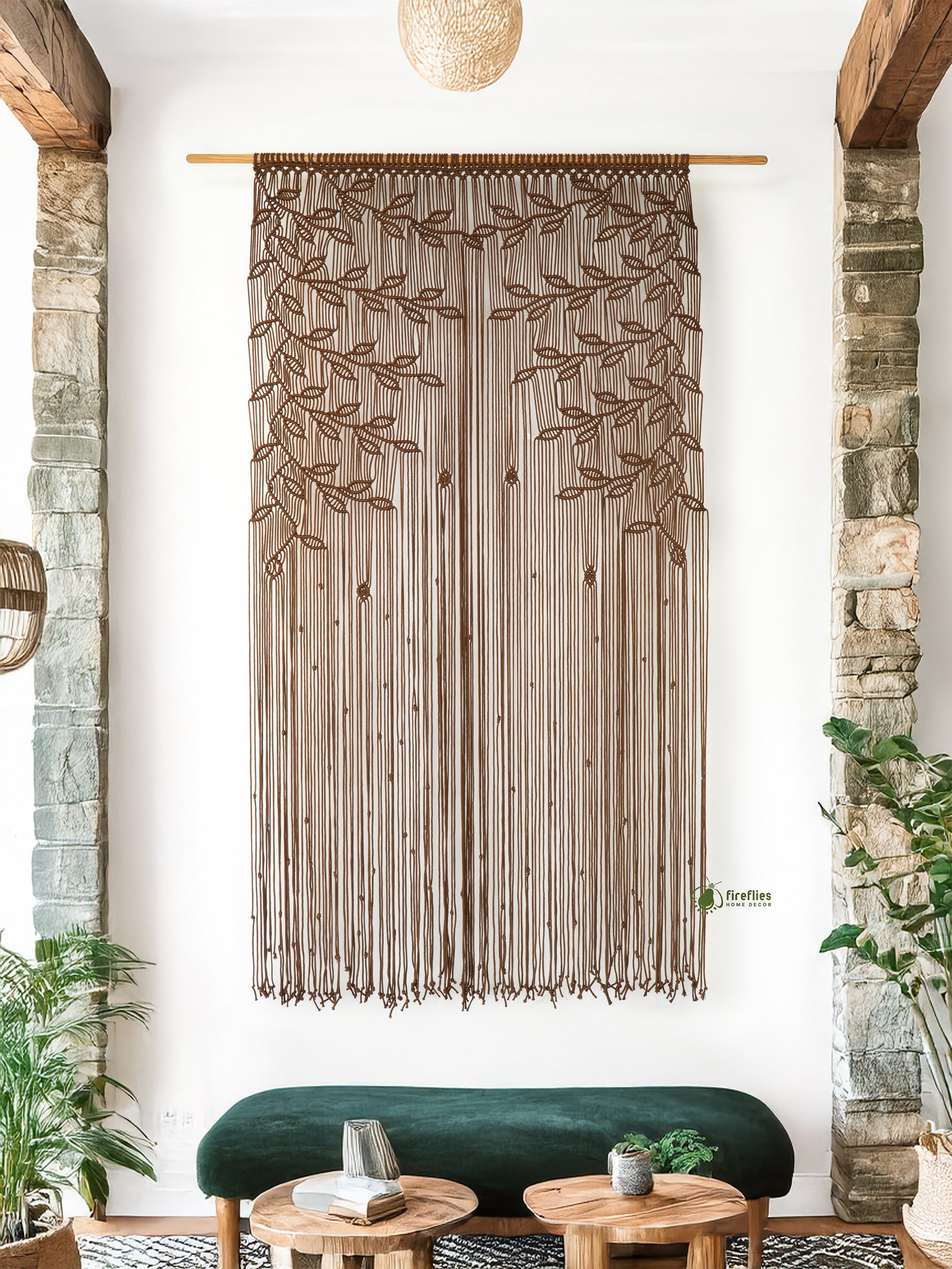 Decorative string curtain with leaf pattern hanging in a room with stone walls and green sofa.
