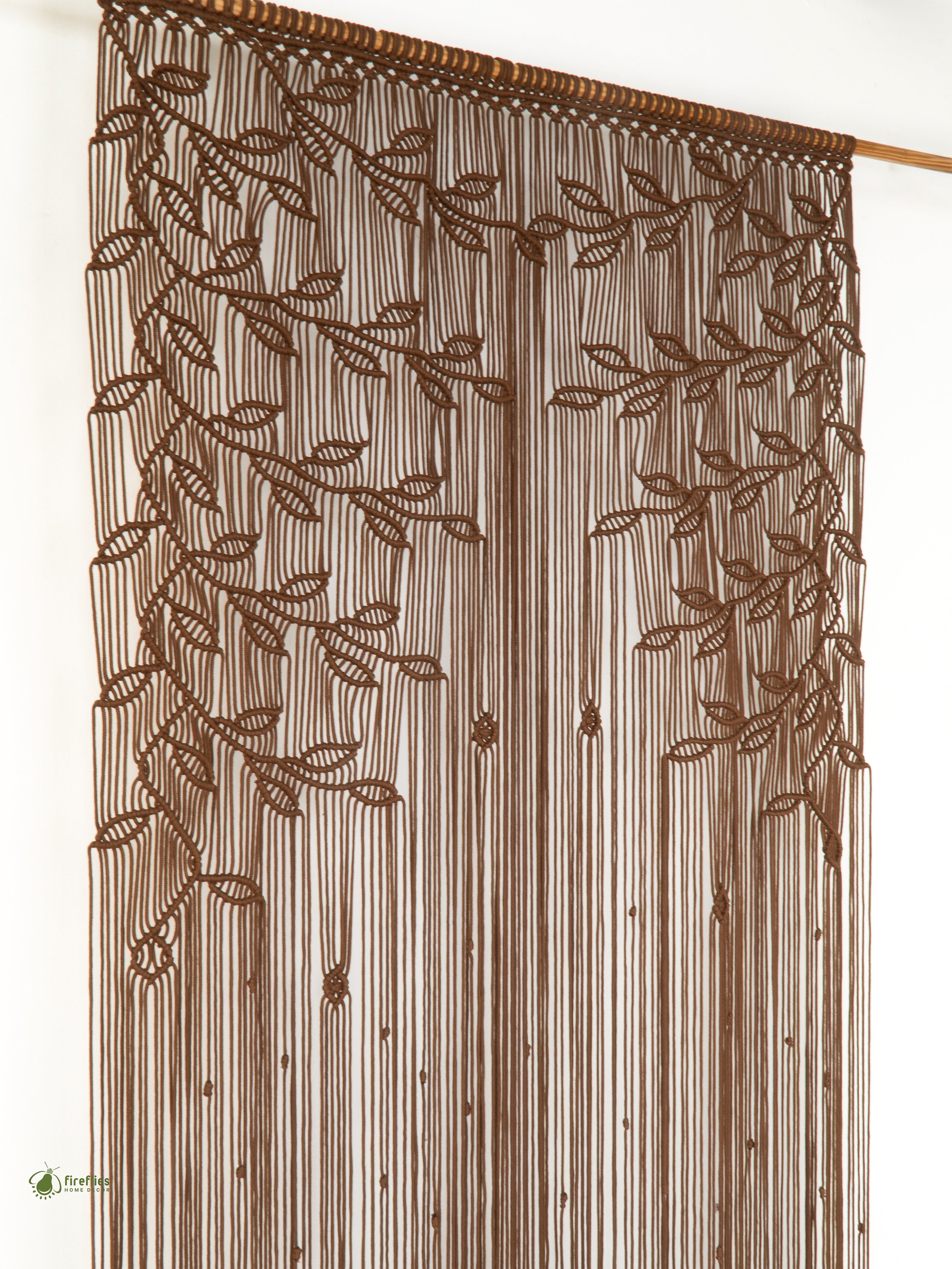 Brown embroidered curtain with leaf patterns on a white background