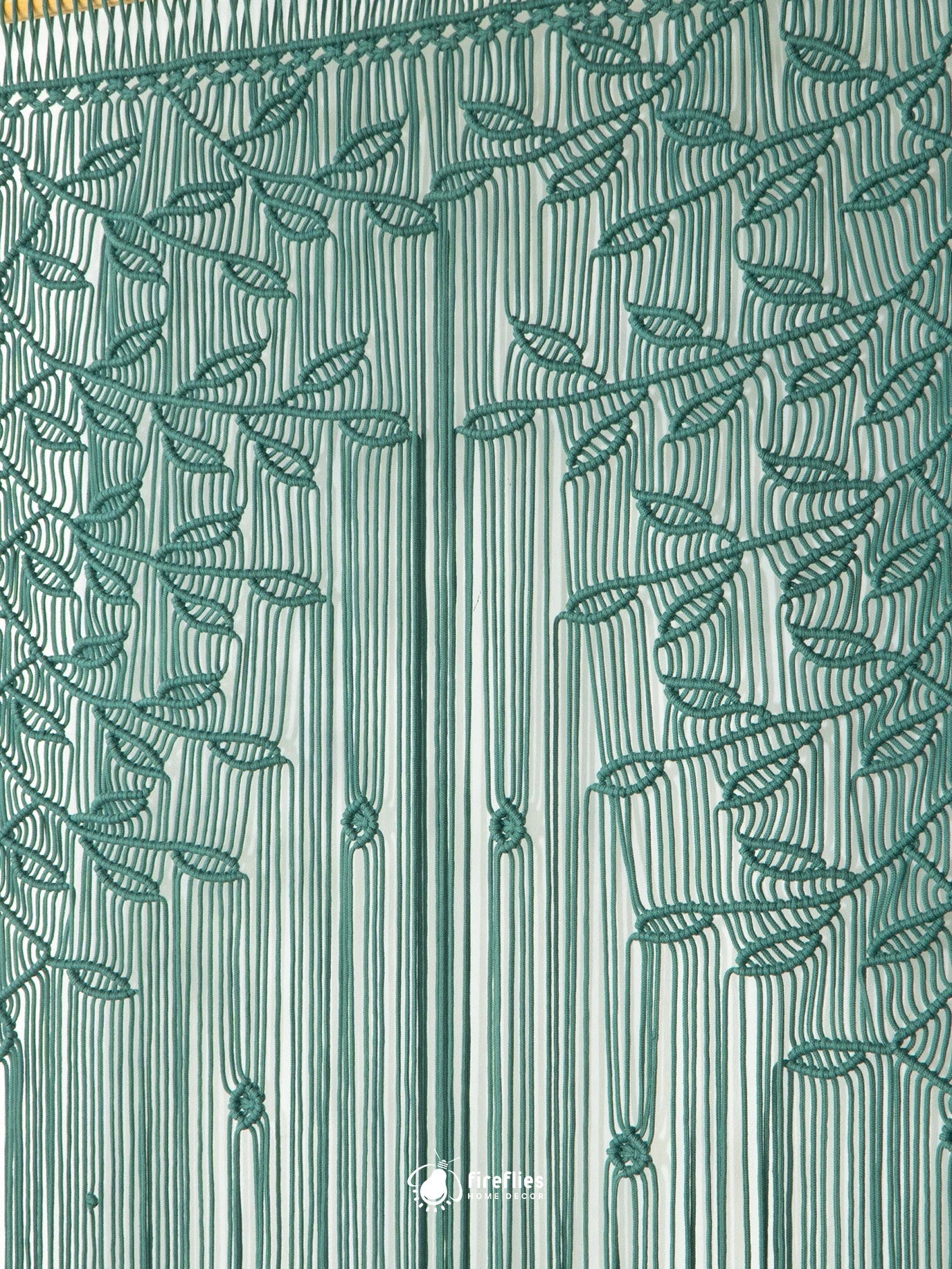 A close-up of a green embroidered curtain panel featuring a leafy vine pattern over a striped background.