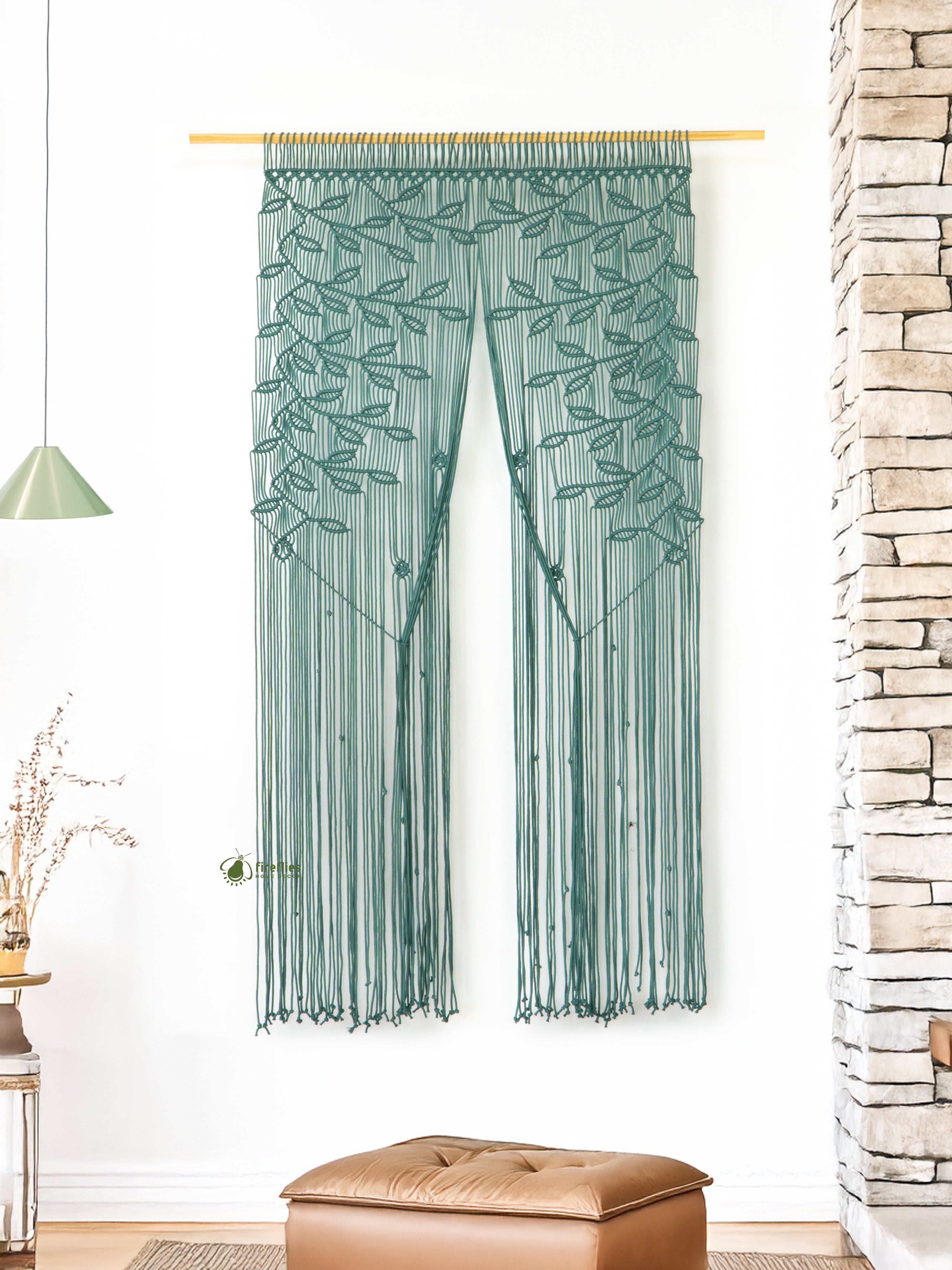 Green leaf-patterned curtain hanging in a room with a stone wall and wooden floor.