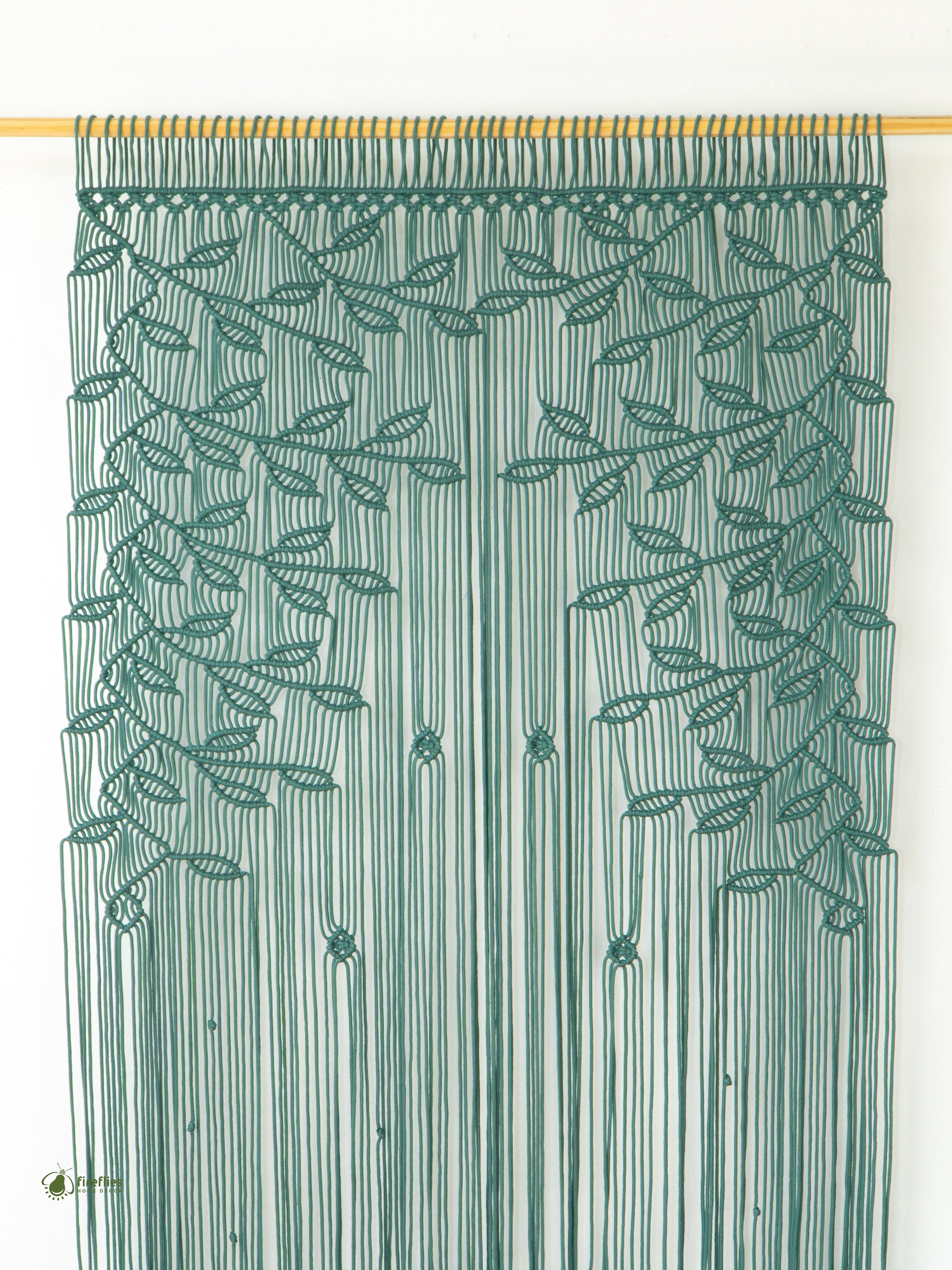 Green woven curtain with a wooden rod on a white background