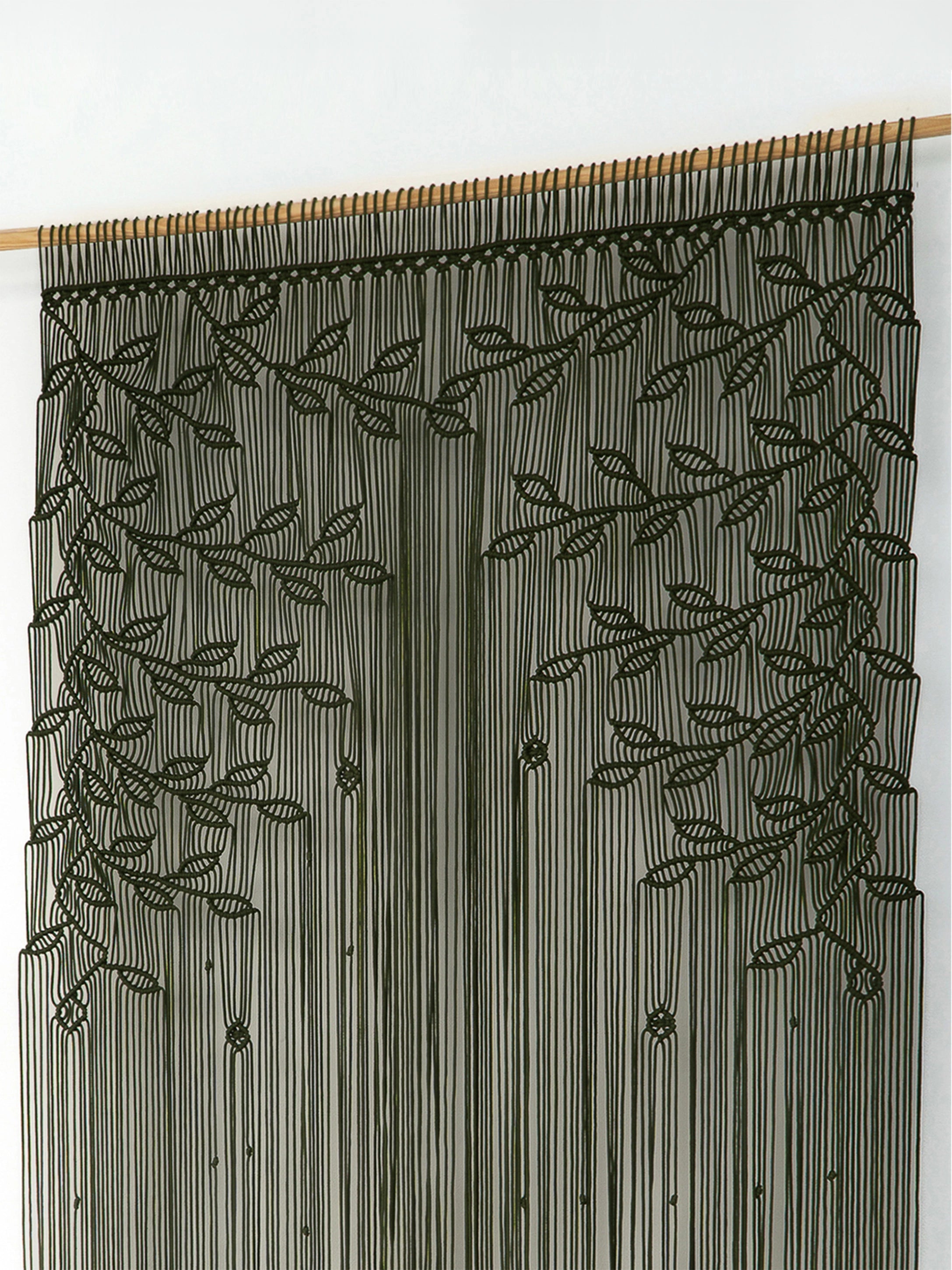 A dark olive green beaded curtain featuring embroidered leaf and vine patterns, hanging from a light wood rod against a plain white wall.