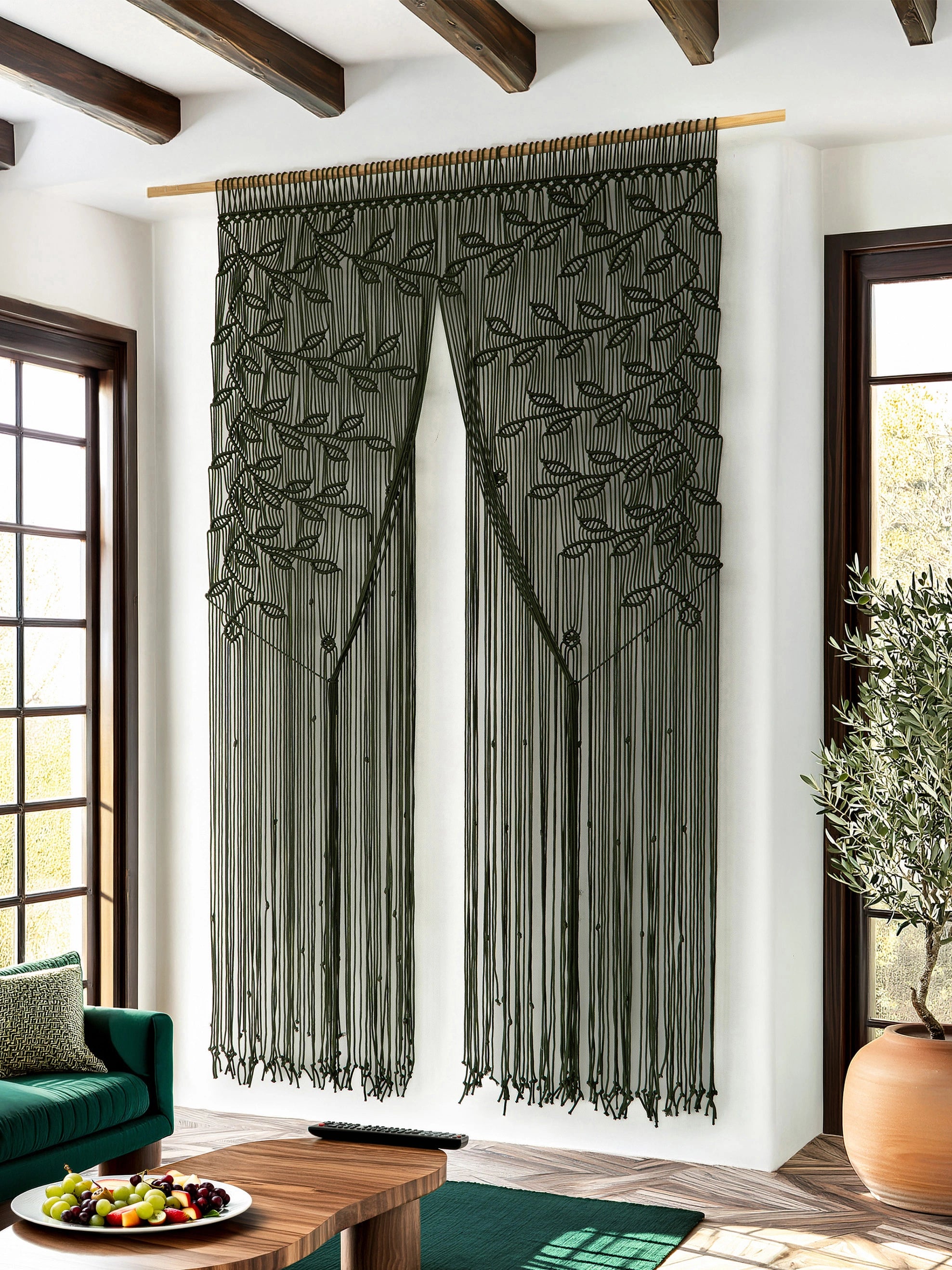 Full-length dark green macrame walkthrough curtain pulled back to open the view into a bright kitchen.