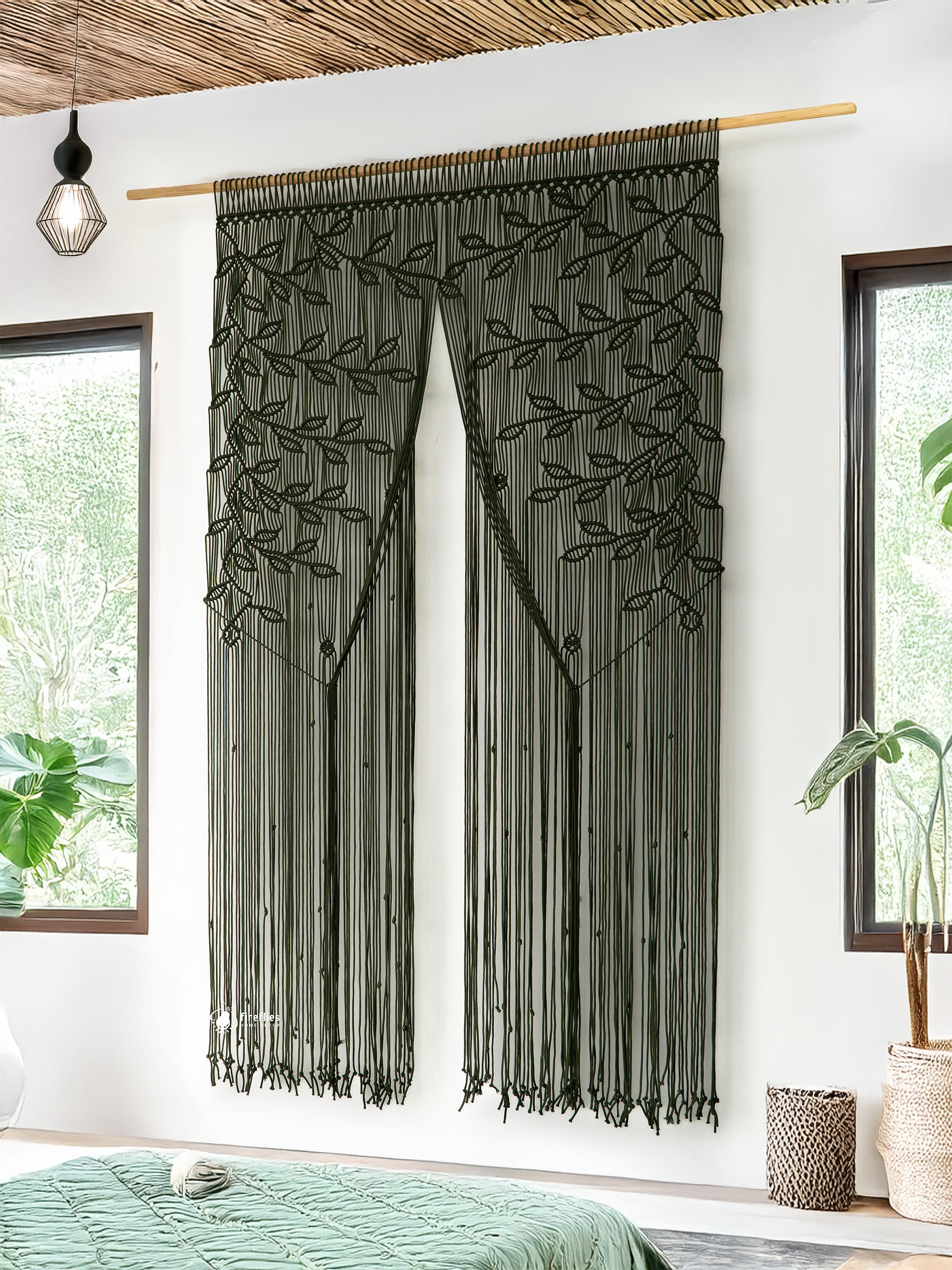 Decorative string curtain with leaf pattern hanging in a room with windows and plants.