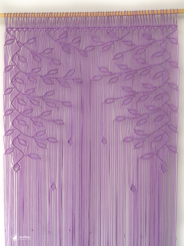 Purple string curtain with leaf pattern on a wooden rod