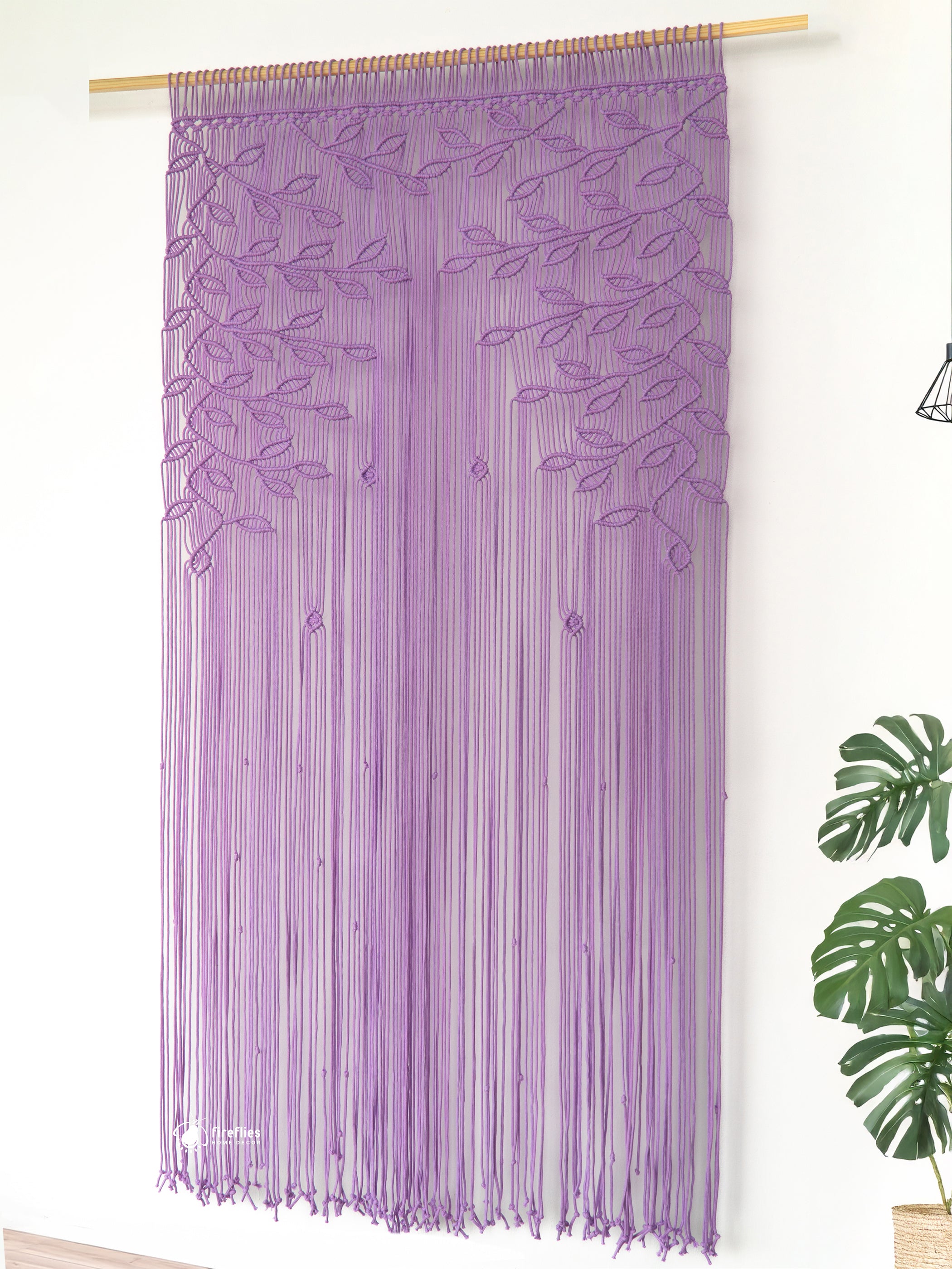 Purple string curtain with leaf patterns on a white wall