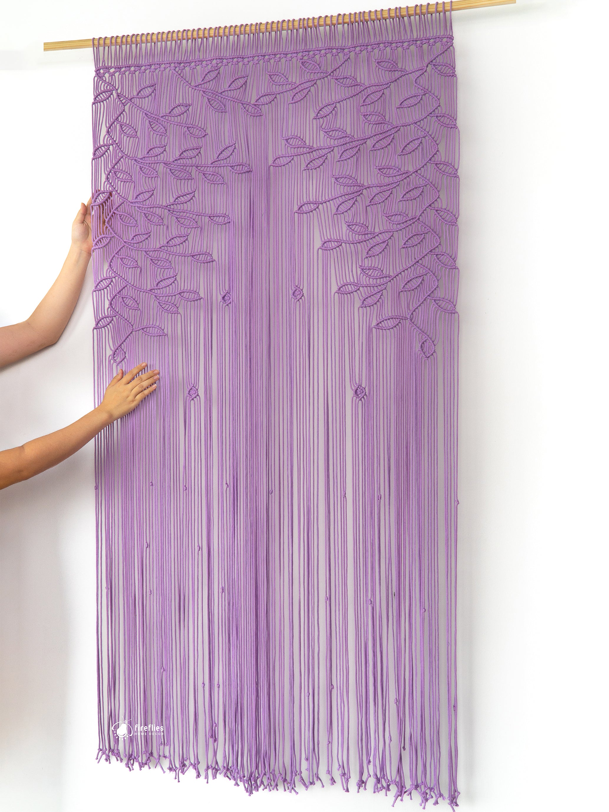 Purple string curtain with a person holding it on a white background