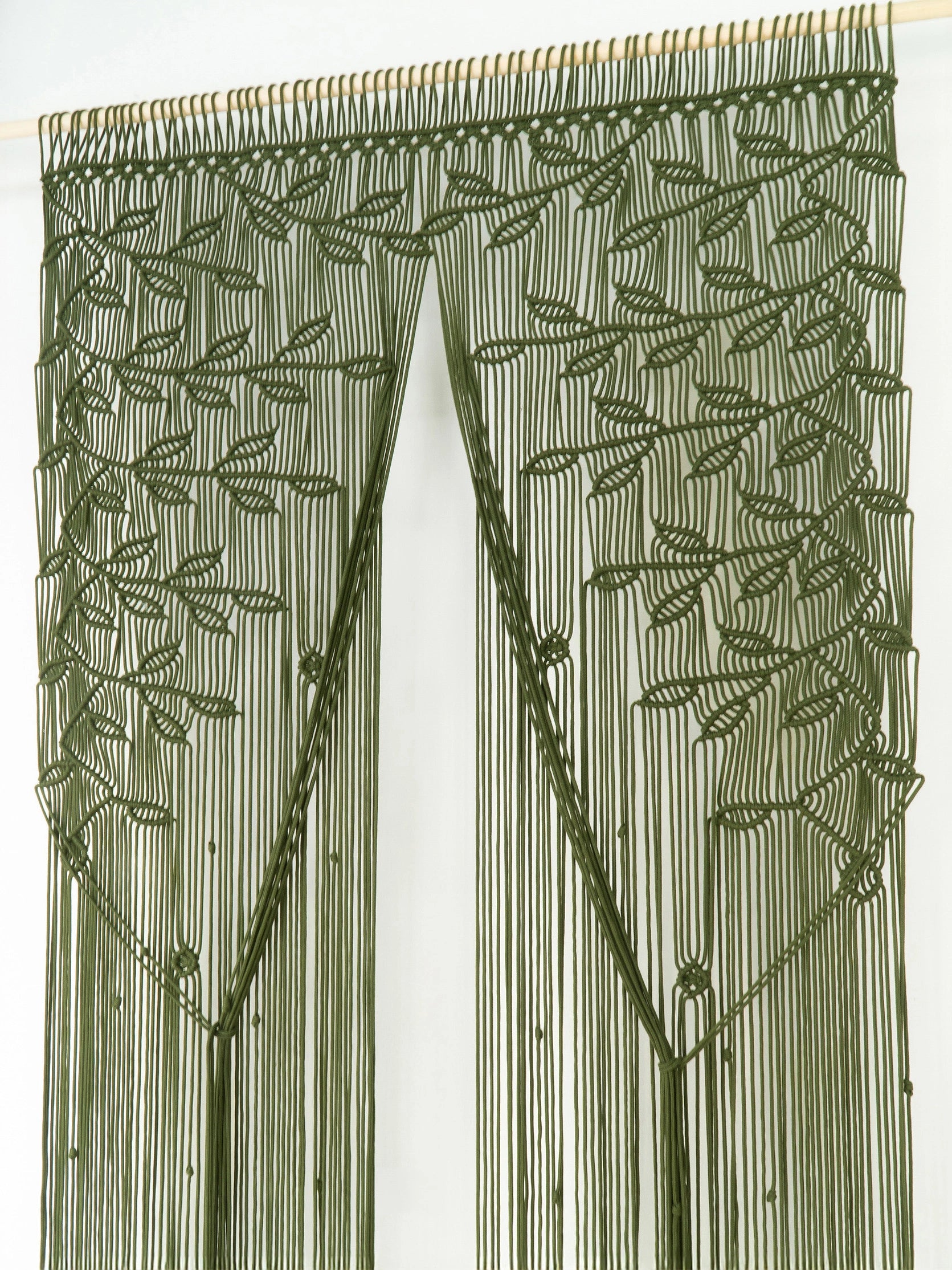 An olive green beaded curtain featuring a leafy vine pattern and long hanging strands, shown hanging from a wooden rod against a plain white background.