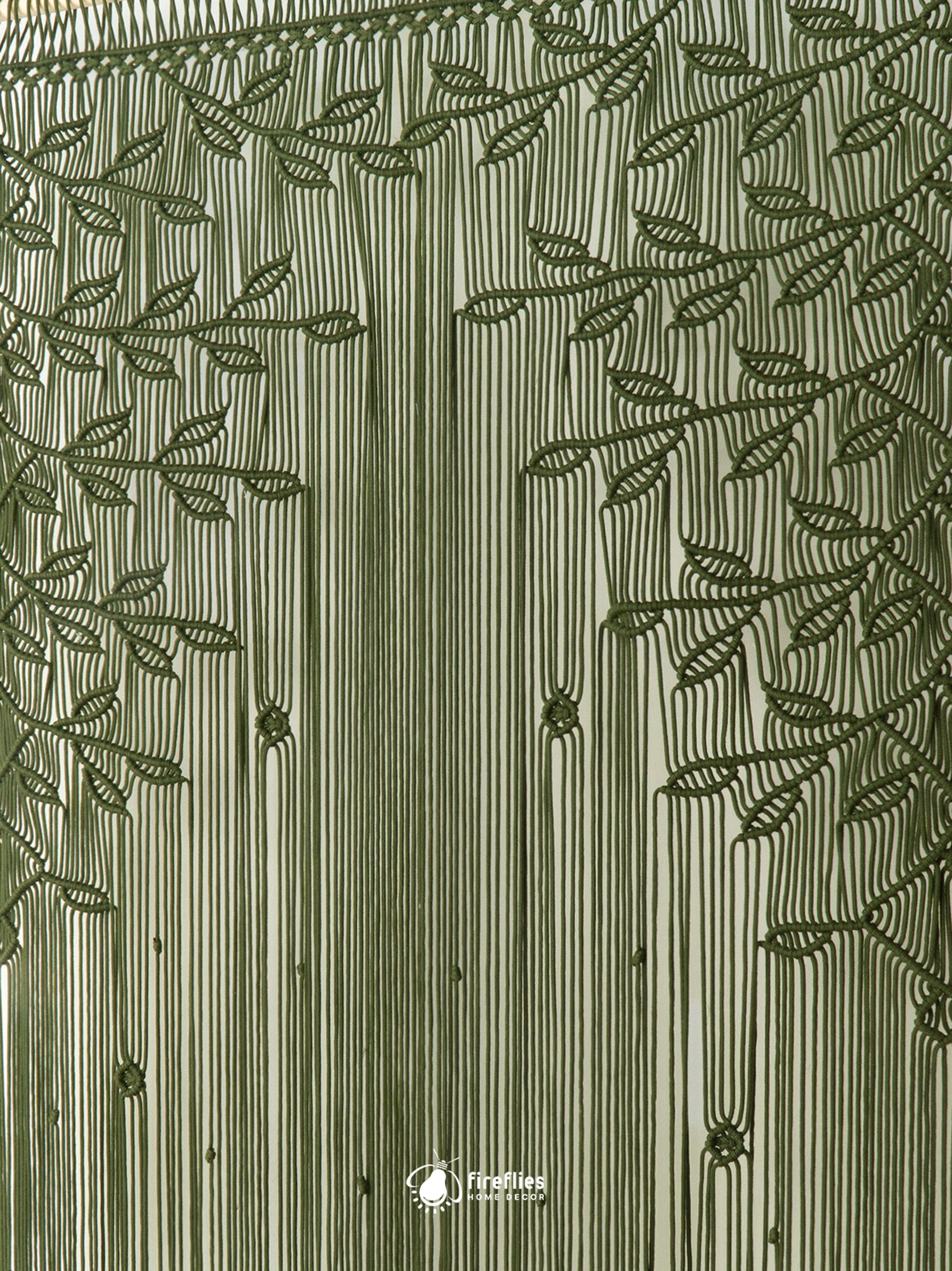 Handcrafted bohemian fiber art tapestry featuring knotted olive green weeping leaf branches and dense fringe cords.