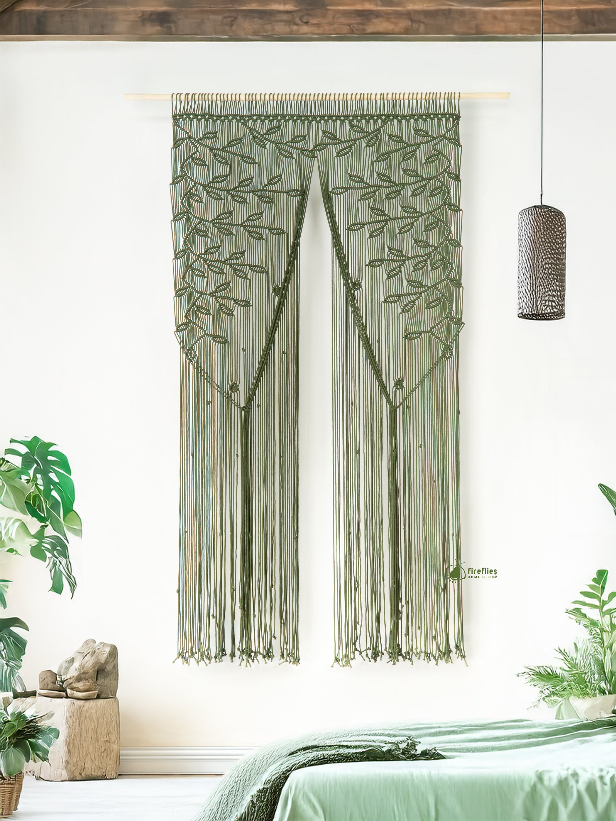 Decorative string curtain with leaf pattern in a room with plants and a lamp.