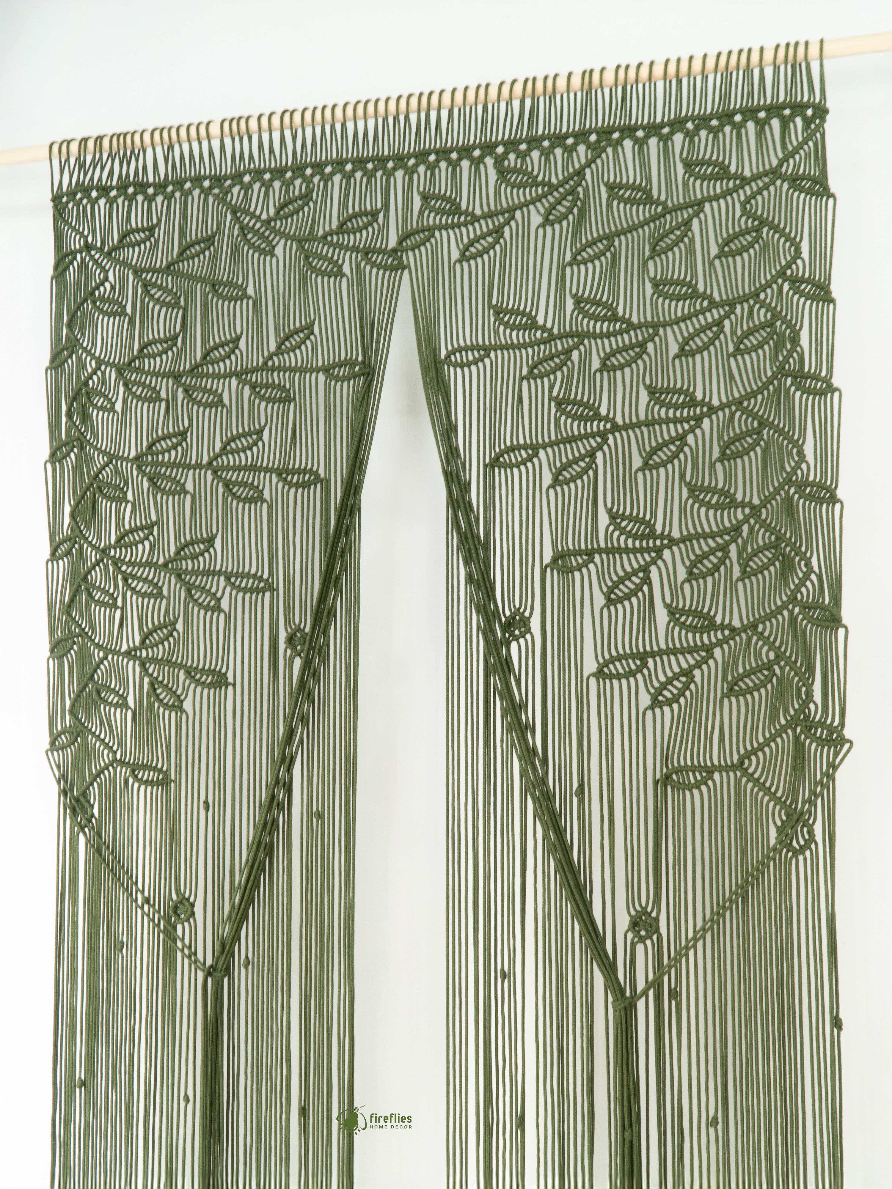 Green embroidered curtain with leaf pattern on a white background