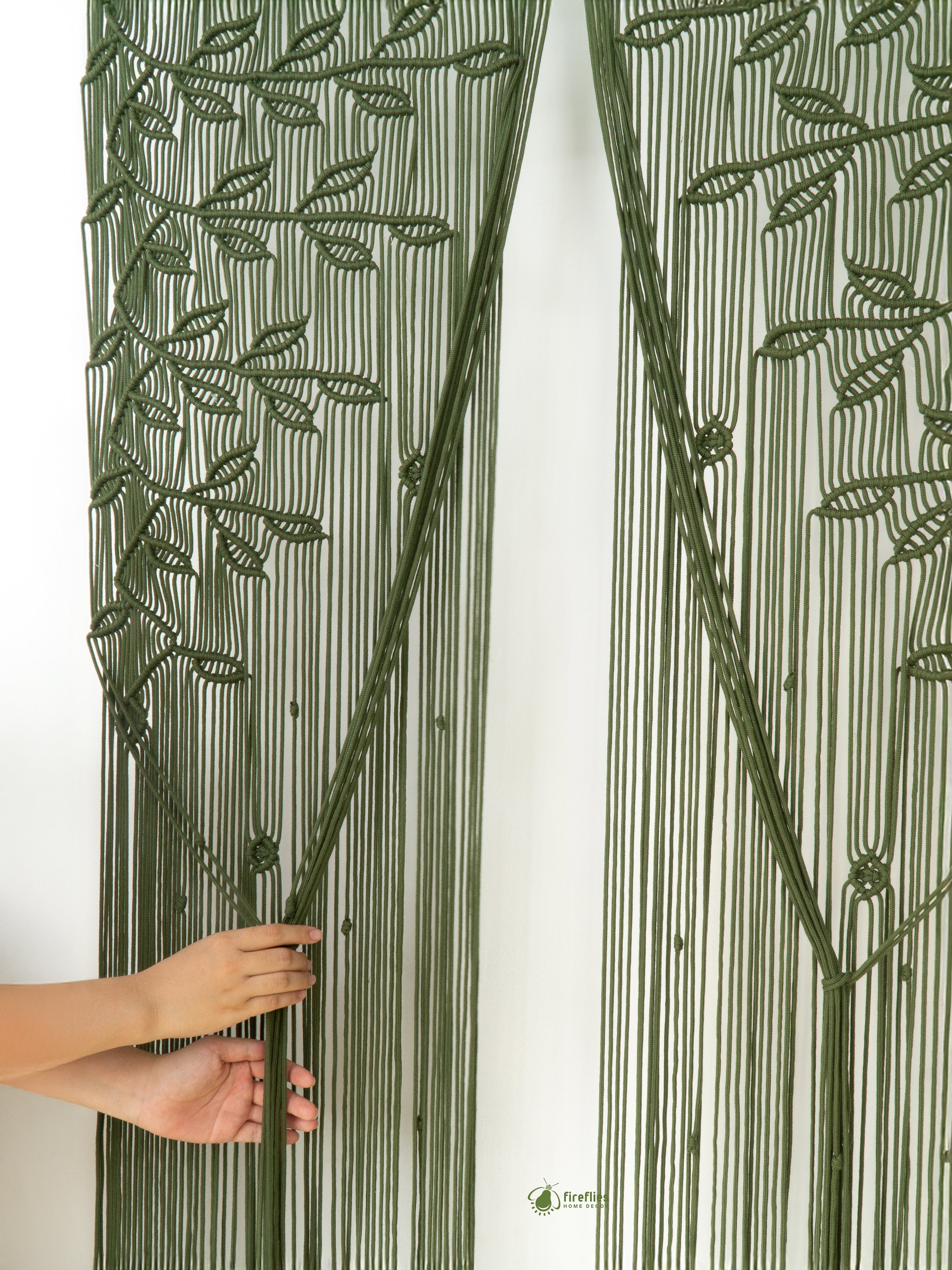 Decorative string art with leaf pattern held by a hand against a white background