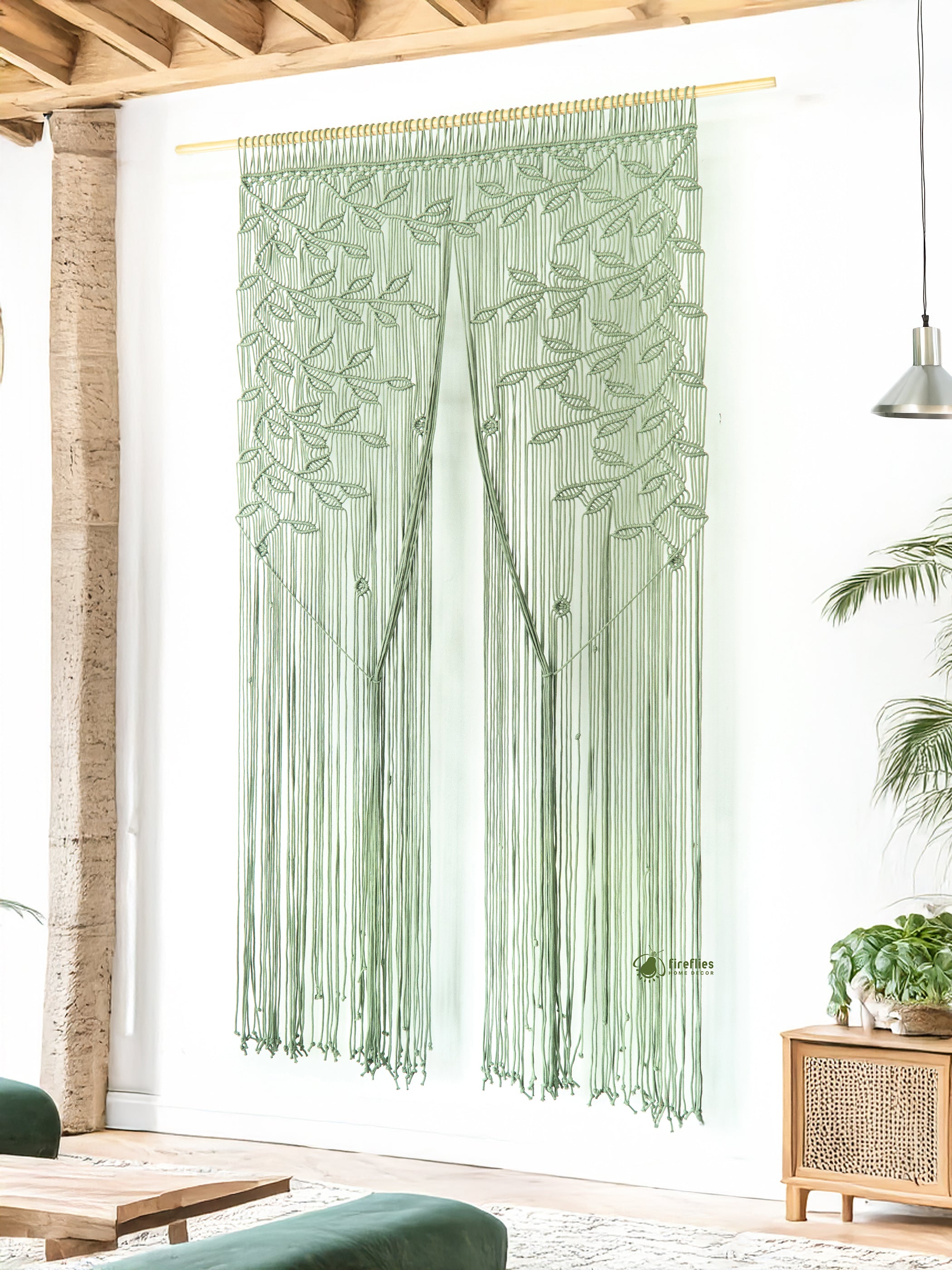 Green macramé curtain hanging in a room with wooden beams and a plant.