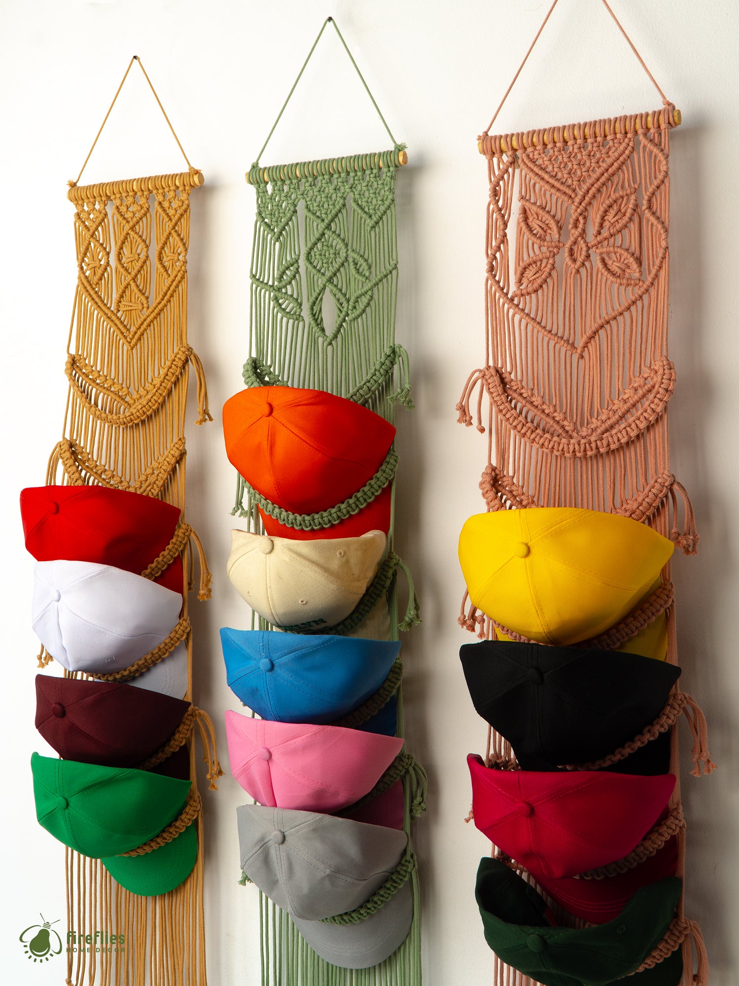 Colorful hats hanging in a macrame hat rack against a white wall.
