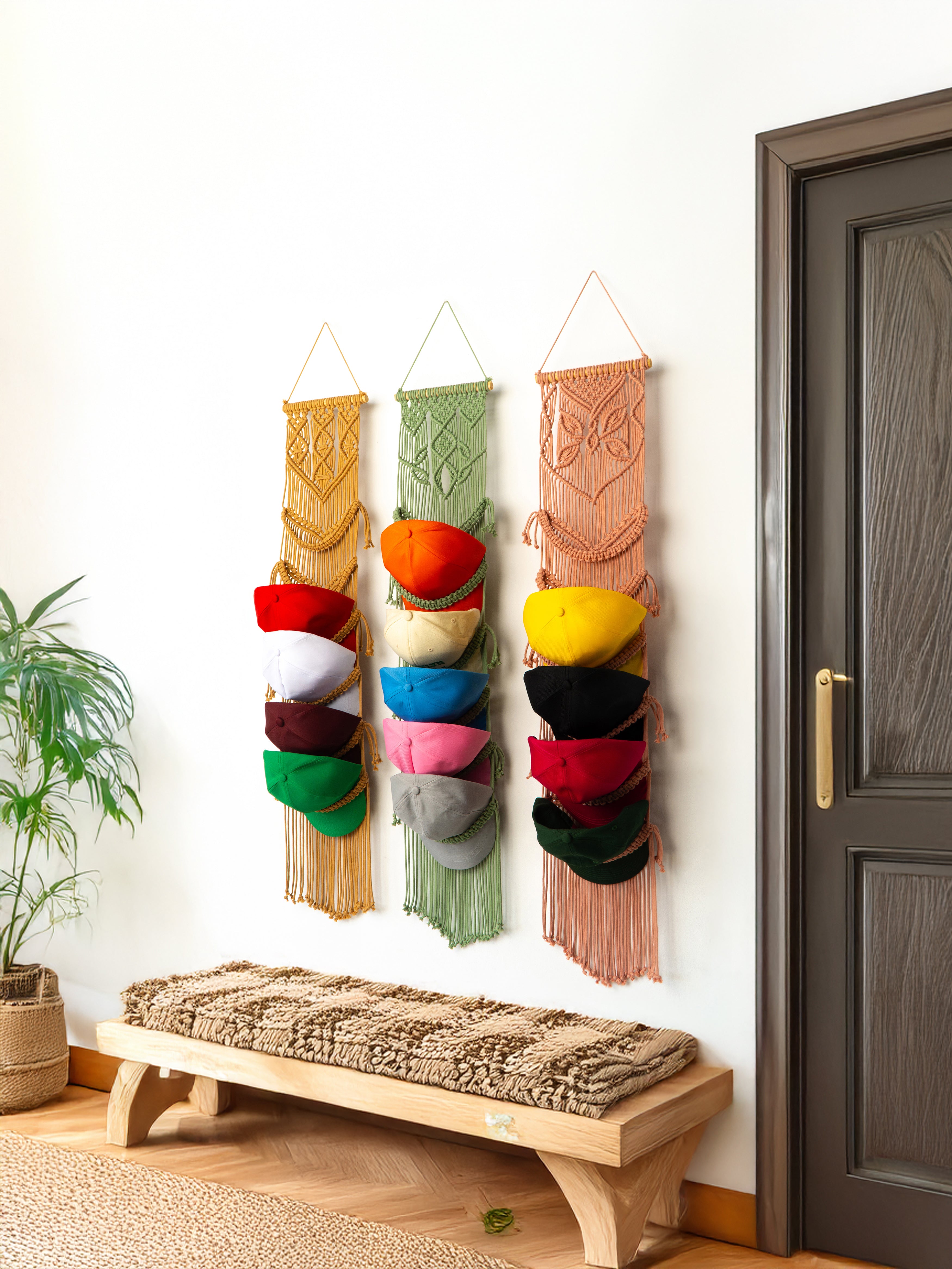 Colorful wall-mounted hat organizer with a wooden bench and plant in a room.