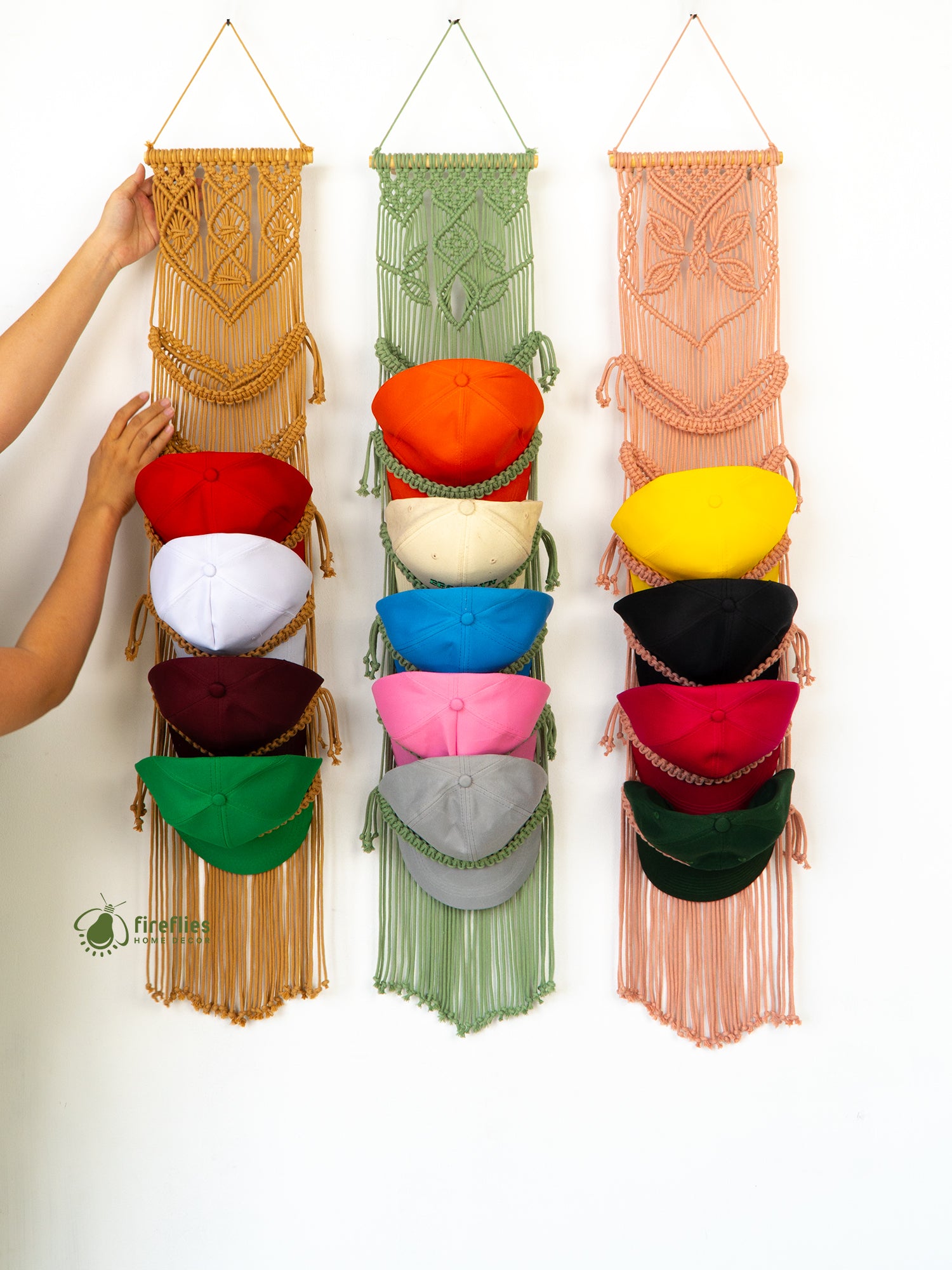Colorful macrame hat rack with hats on a white background