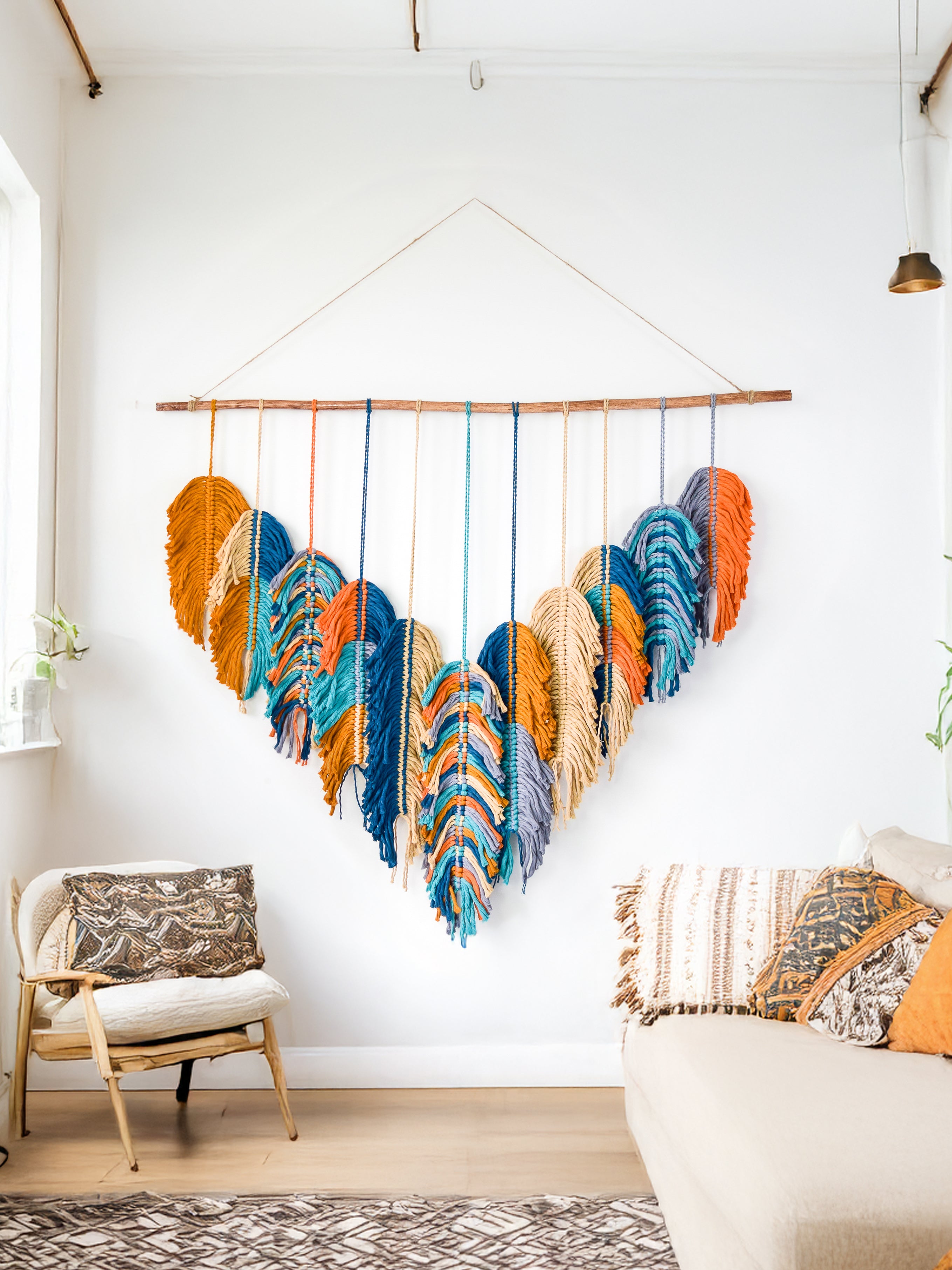 Colorful woven wall art hanging in a room with a chair and couch.
