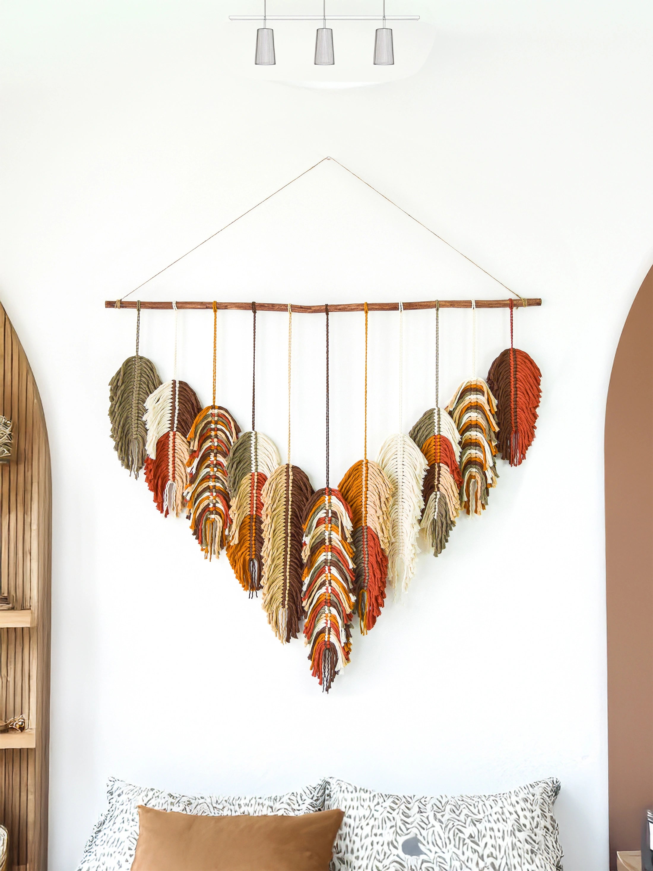 Decorative wall hanging with colorful yarn on a white wall in a living room.