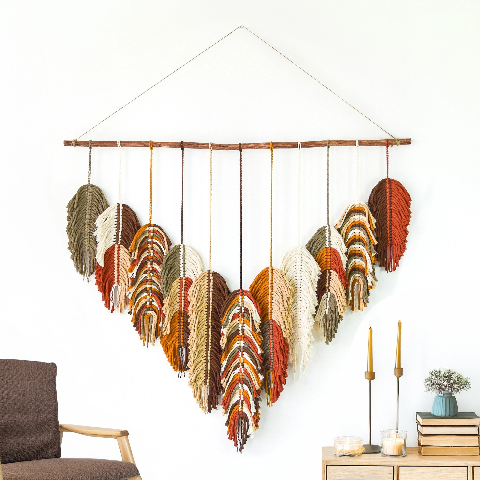 Decorative wall hanging with feathers in various colors on a white wall.