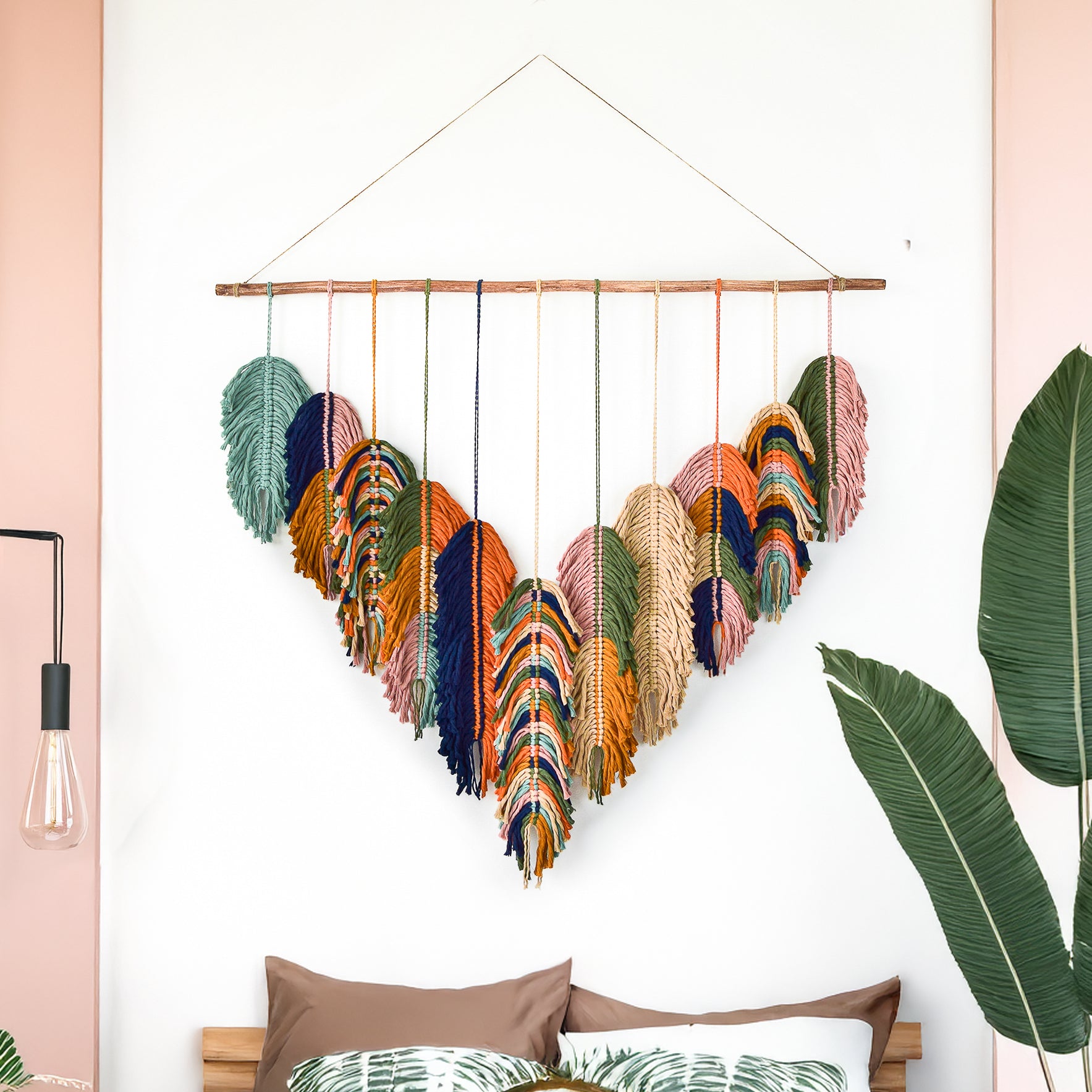 Decorative wall hanging with heart-shaped feathers in a living room setting.