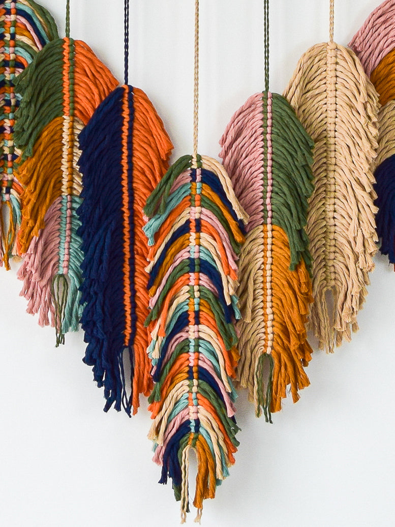 Colorful macrame wall hangings on a white background
