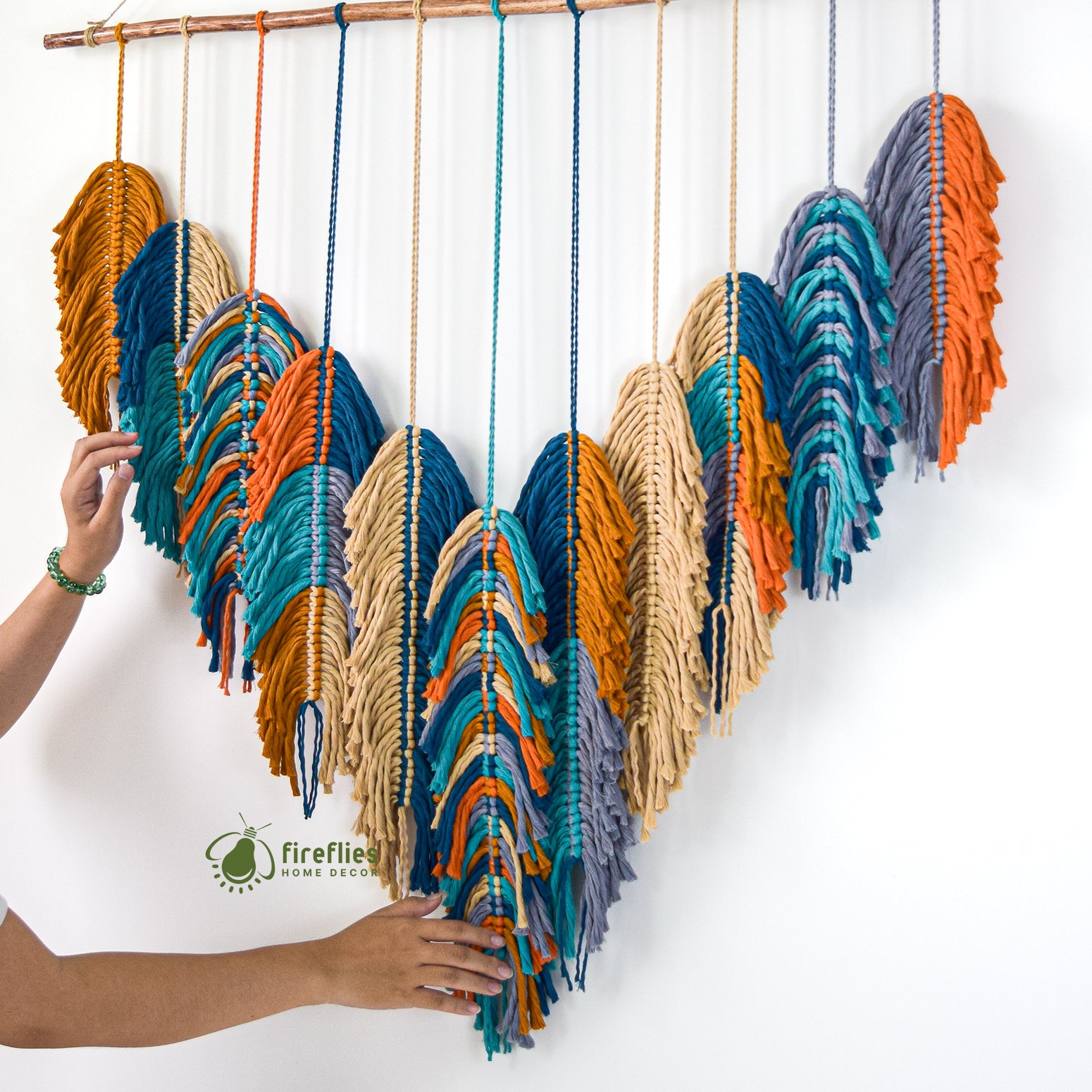 Decorative wall hanging with leaf patterns above a bed with green bedding.